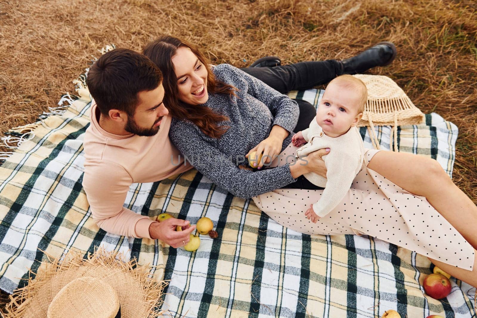 Haves picnic. Happy family of mother, family and little baby rests outdoors. Beautiful sunny autumn nature.