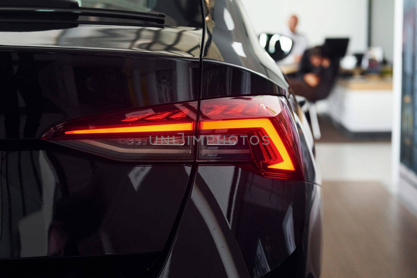 Rear view of the car. Close up focused view of brand new modern black automobile.