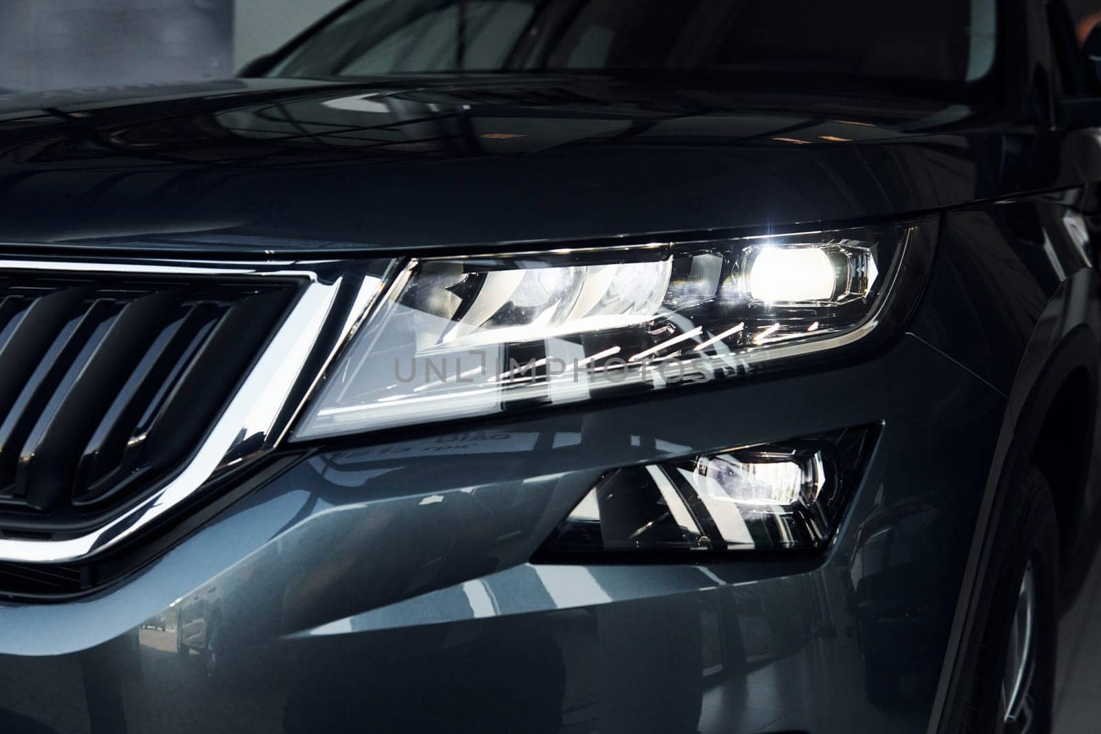 Headlight of car. Close up focused view of brand new modern black automobile.