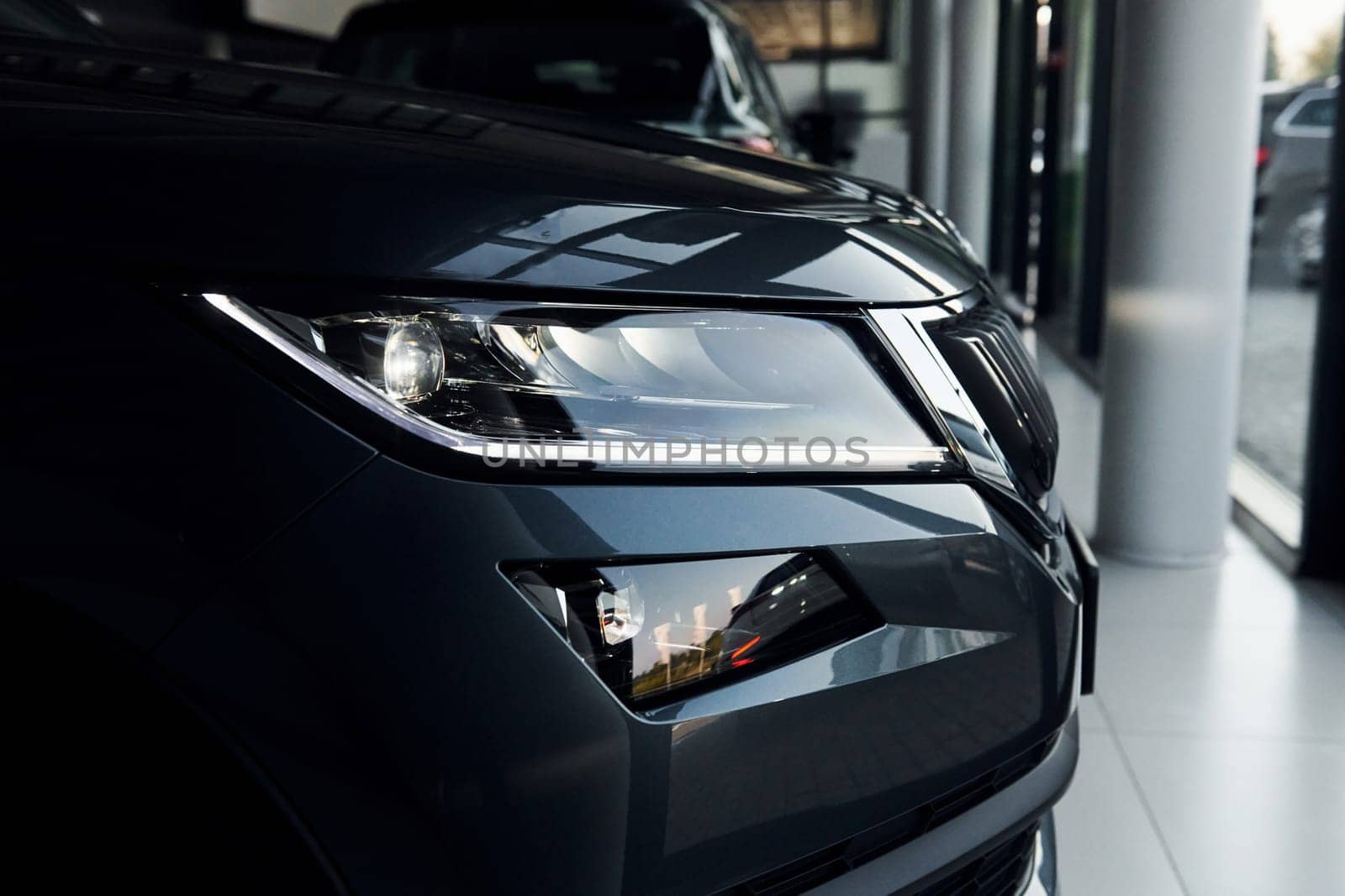 Headlight of car. Close up focused view of brand new modern black automobile.