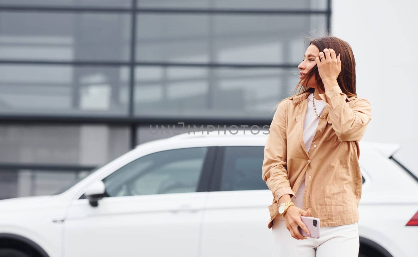 Walks nearby car. Fashionable beautiful young woman and her modern automobile by Standret