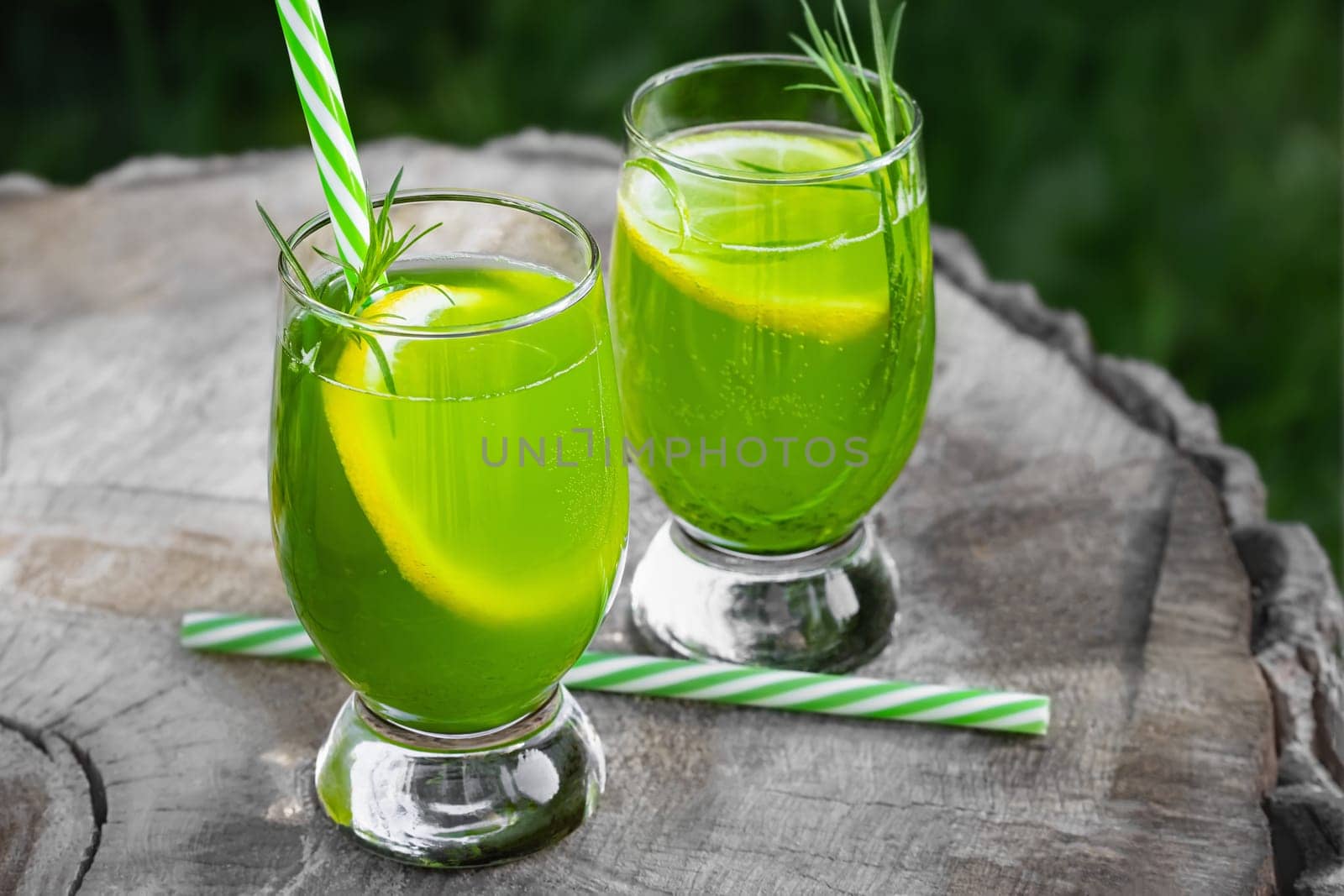 Homemade summer refreshing tarragon lemon drink on patio table.