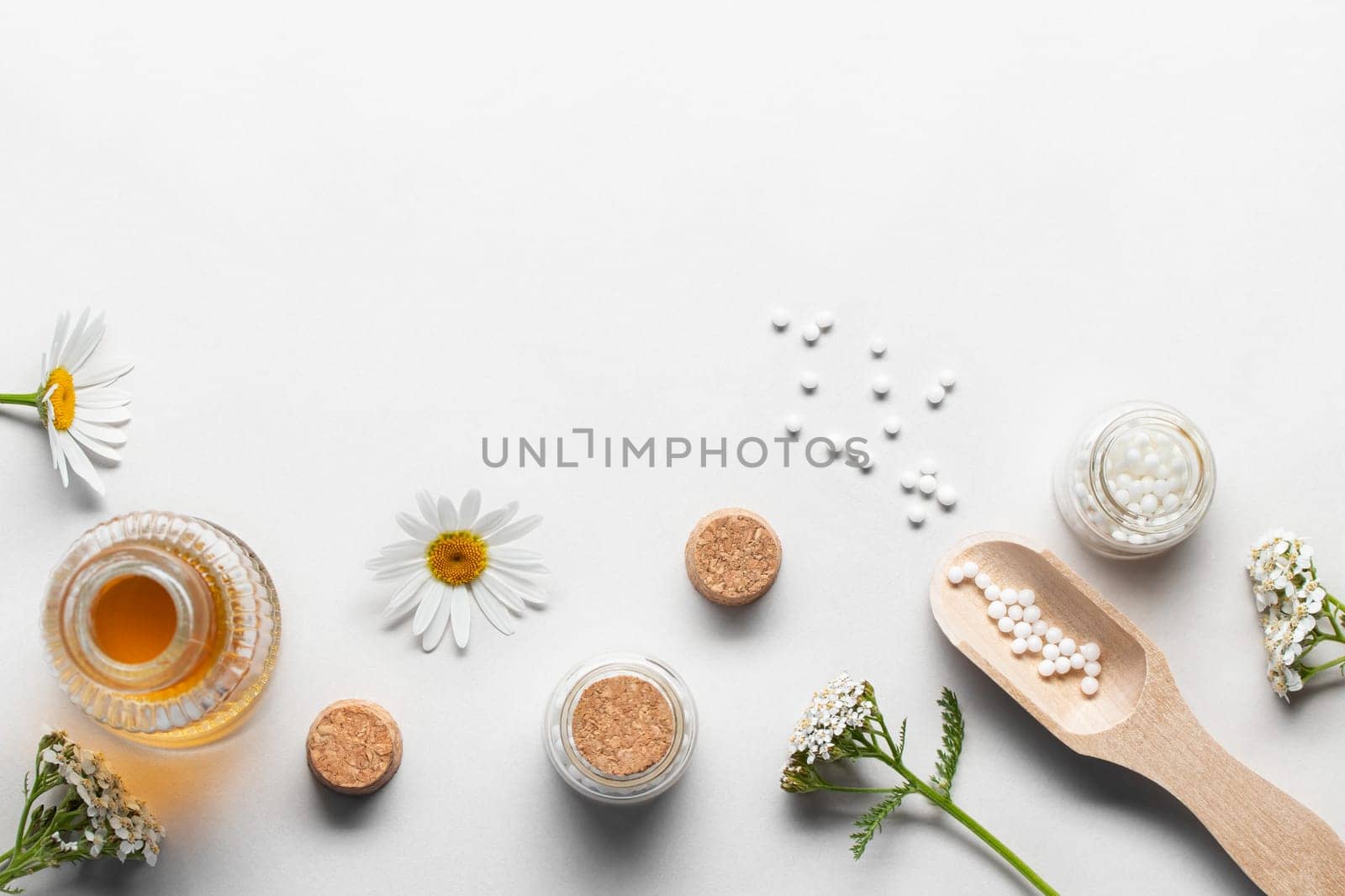 Homeopathic medicines and medicinal plants on a light background, copy space.