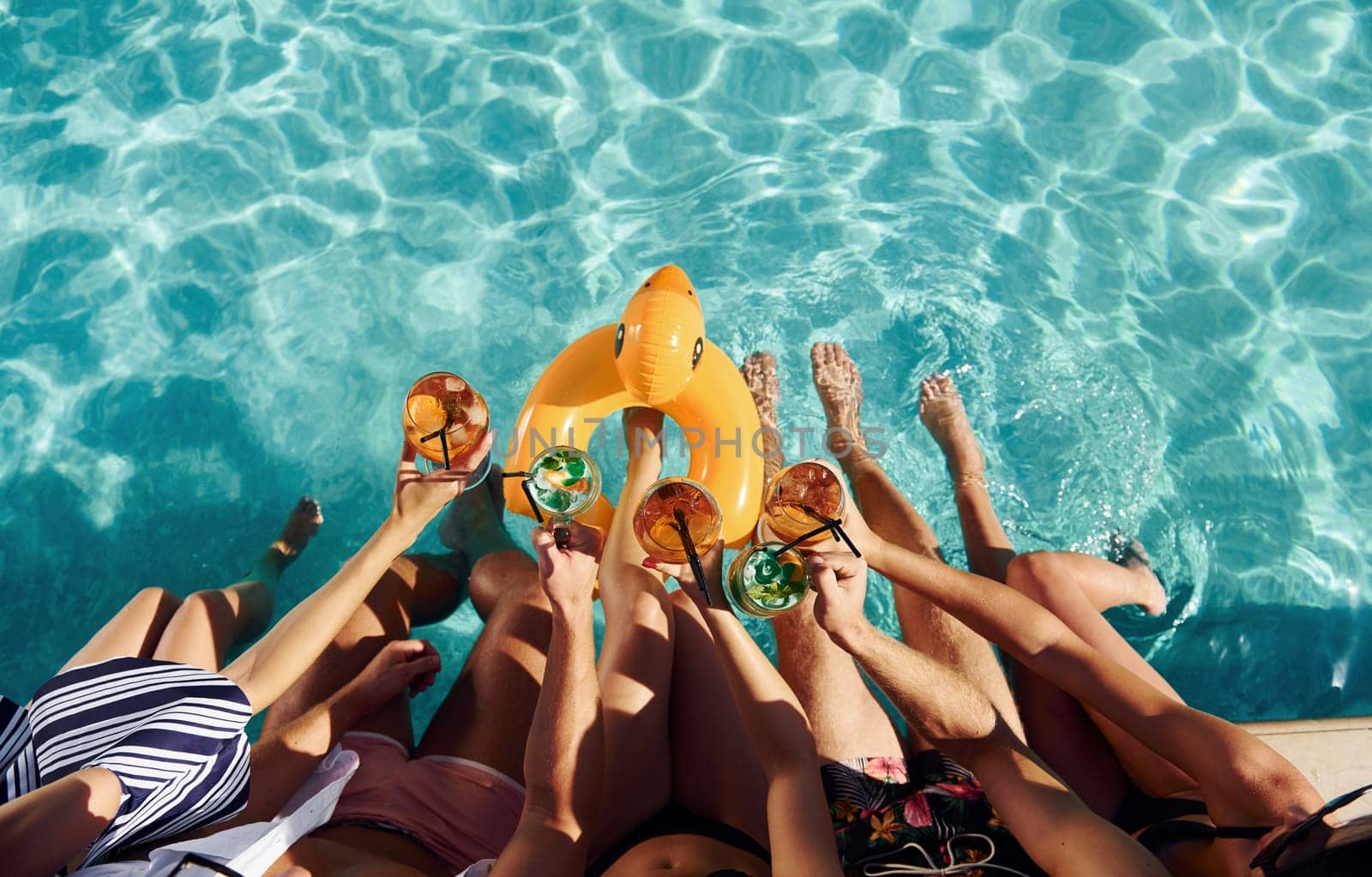 Top view of group of young happy people that have fun in swimming pool at daytime.