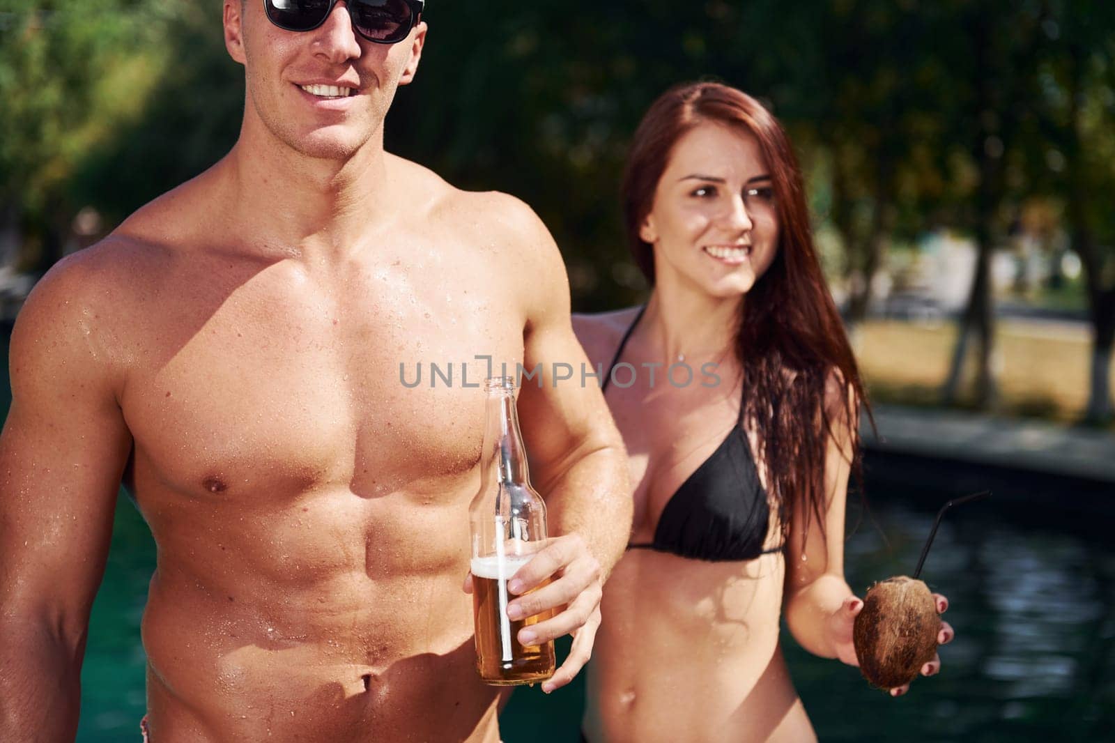 Positive people. Cheerful couple or friends together in swimming pool at vacation.