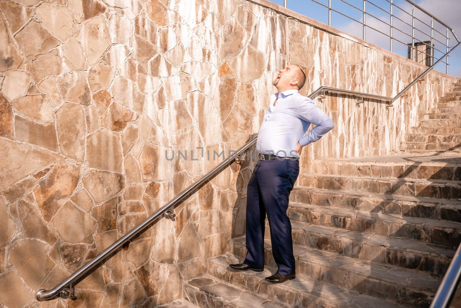 Portrait of a senior professional man in a suit with various problems. A middle-aged businessman with a briefcase descends the stairs.