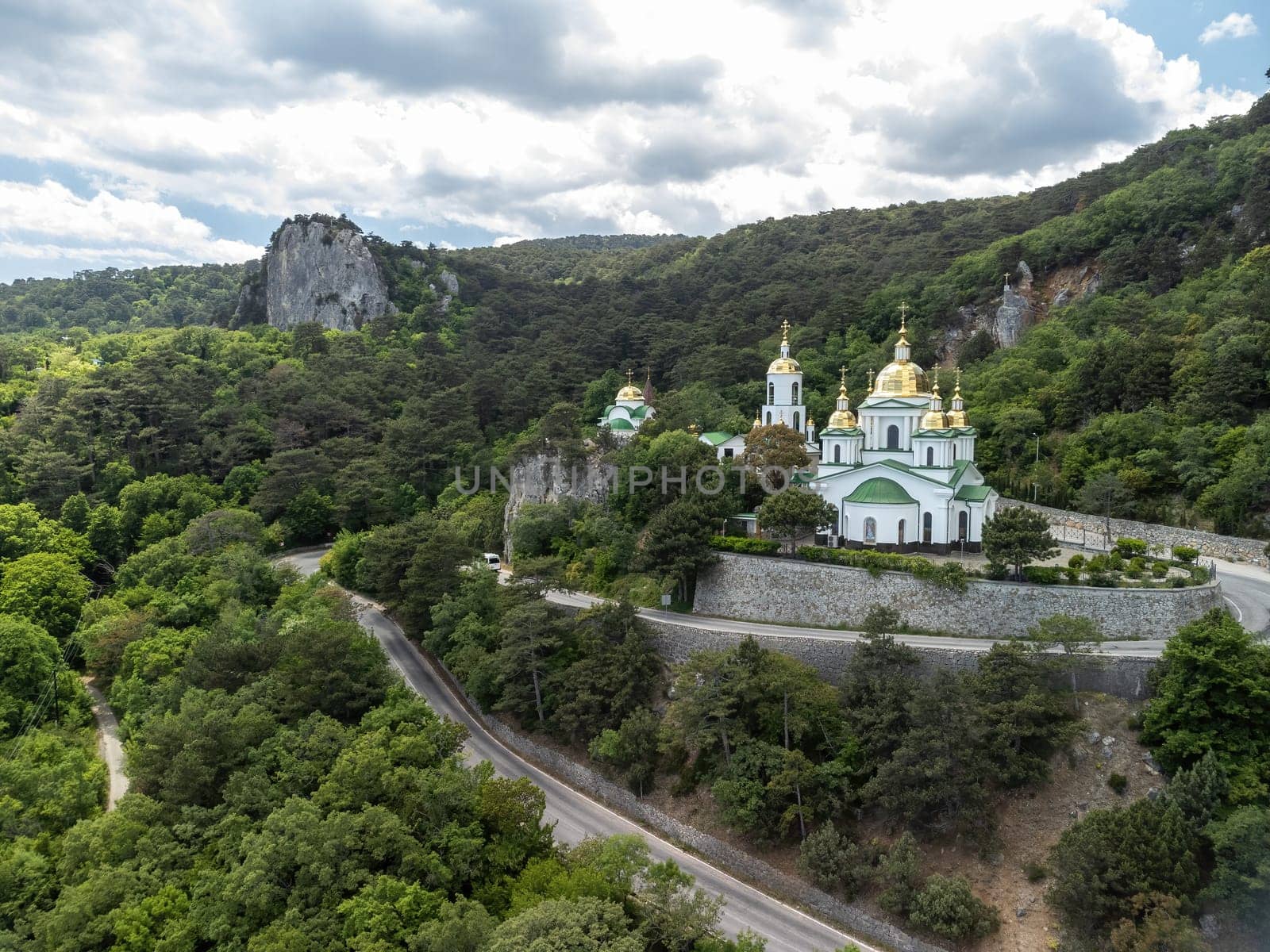 Christian church on a background of mountains. Temple of the Holy Archangel Michael in Oreanda. The southern coast of Crimea. Located on a rocky cliff and is surrounded by beautiful vegetation