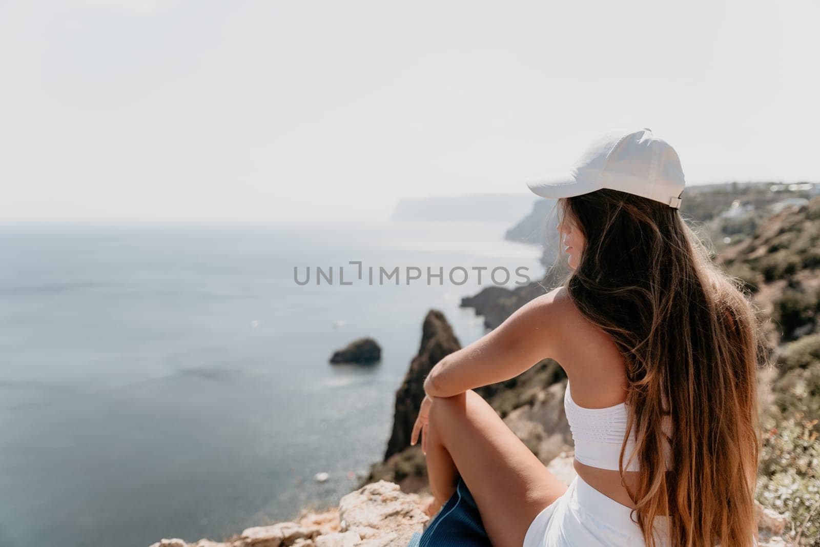 Woman sea yoga. Happy woman meditating in yoga pose on the beach, ocean and rock mountains. Motivation and inspirational fit and exercising. Healthy lifestyle outdoors in nature, fitness concept. by panophotograph