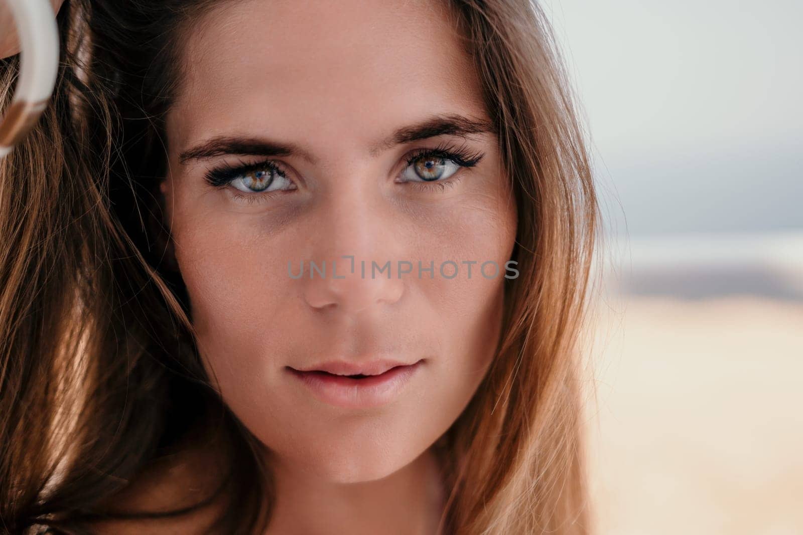 Happy woman portrait in cafe. Boho chic fashion style. Outdoor photo of young happy woman with long hair, sunny weather outdoors sitting in modern cafe. by panophotograph