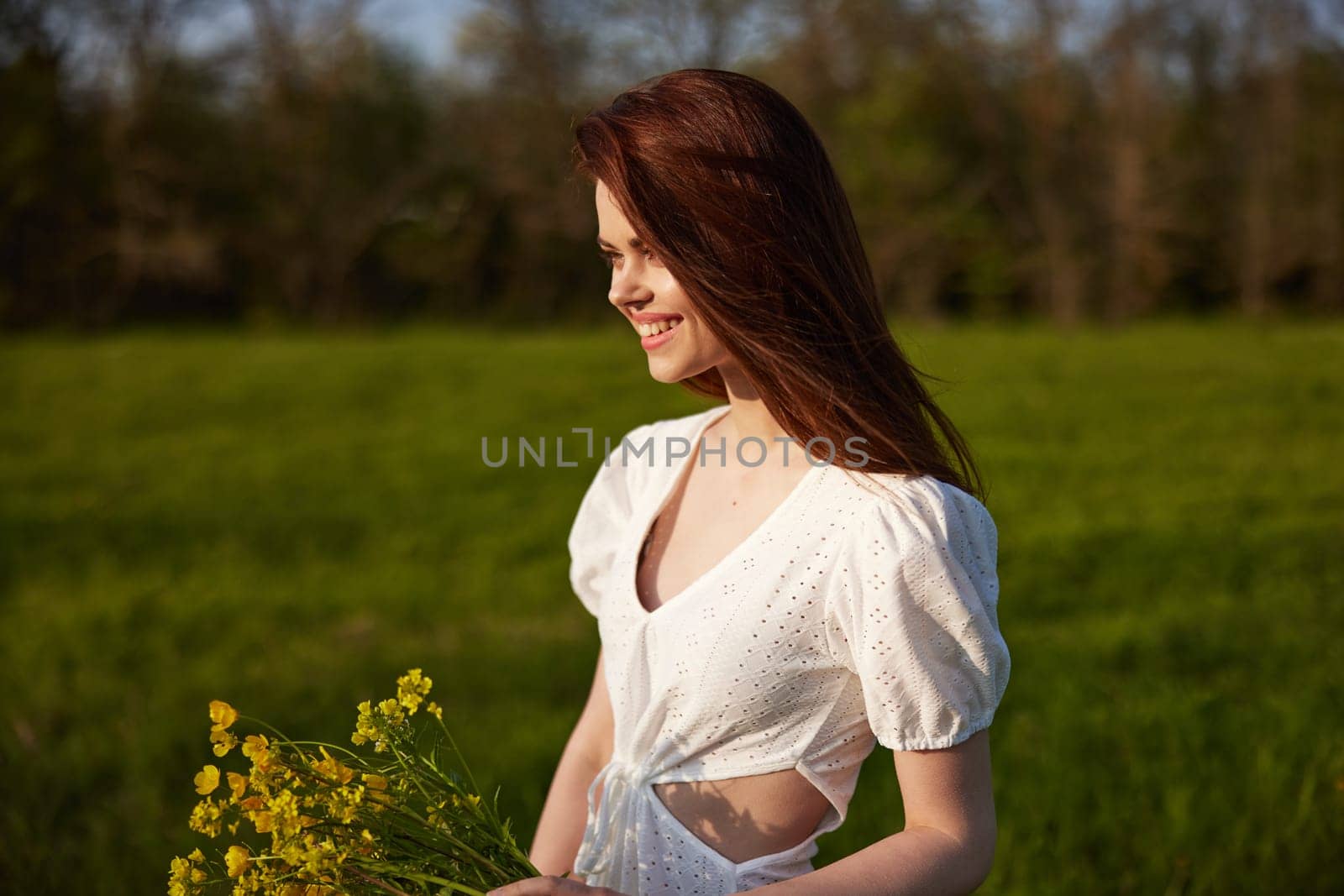 portrait of a beautiful woman with a bouquet of buttercups in her hands in a white dress in nature by Vichizh