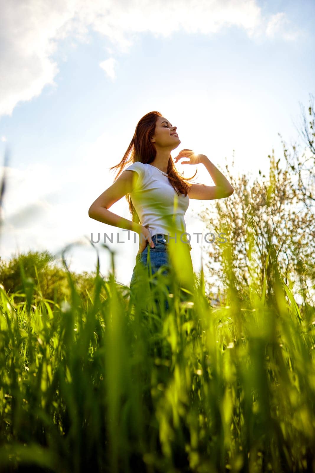silhouette of a woman standing in a field illuminated from the back. High quality photo