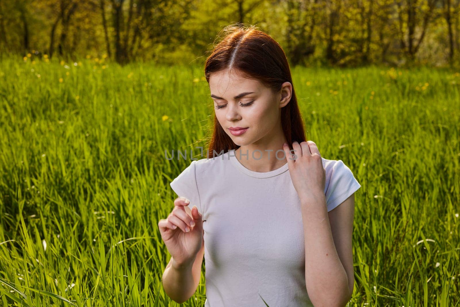 portrait of a pensive woman sitting in the grass in nature. High quality photo