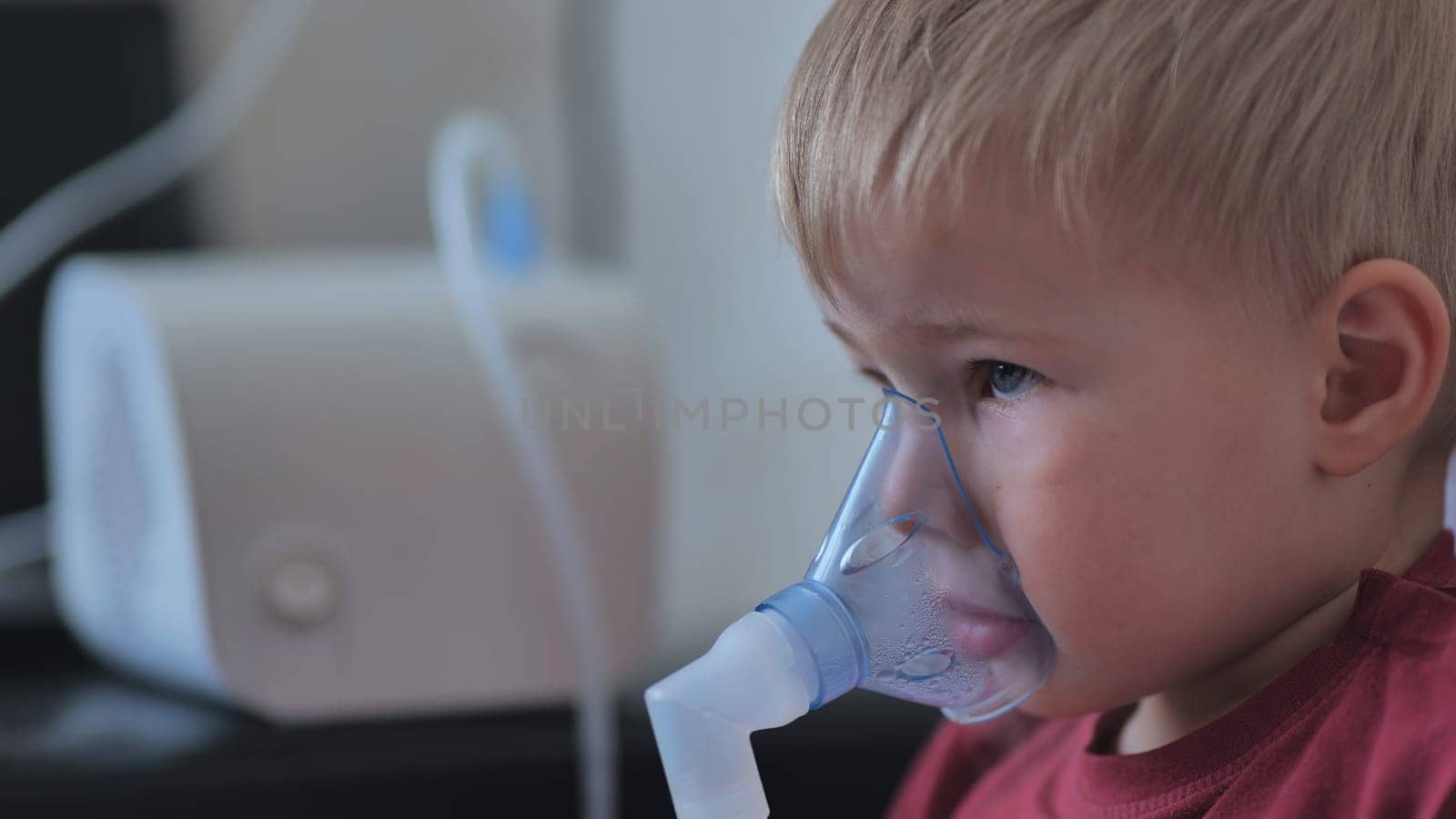 Funny boy breathing through an inhaler mask