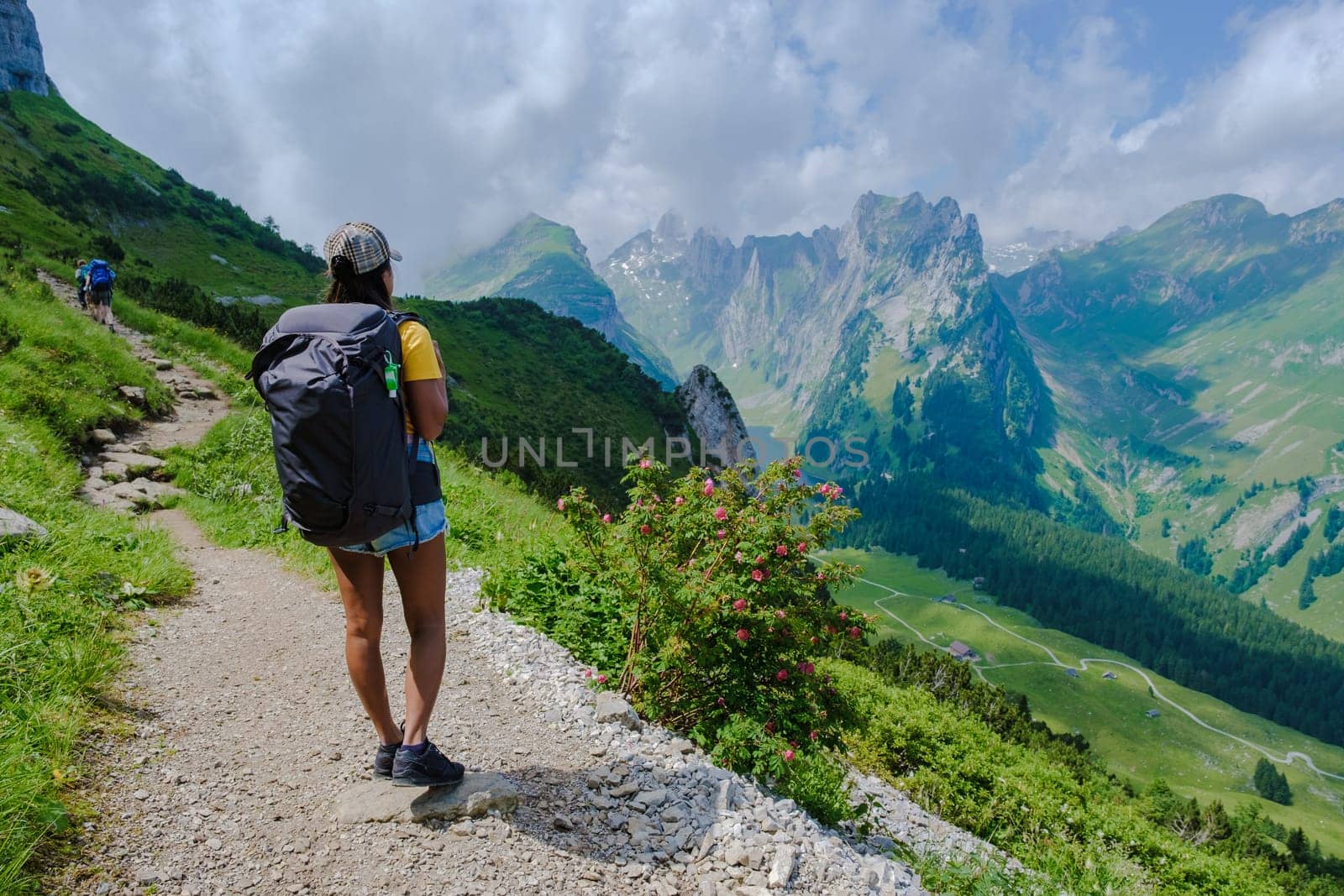 women hiking in the Swiss Alps mountains at summer vacation with a backpack and hiking boots by fokkebok