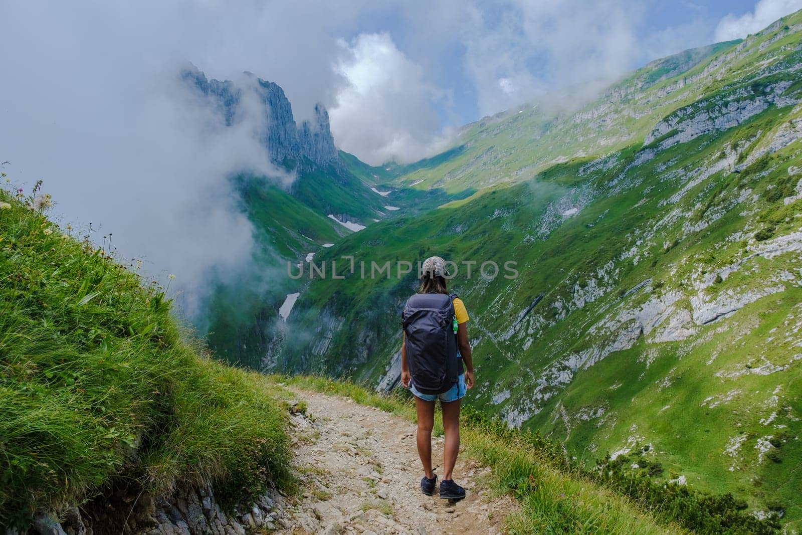 Asian women hiking in the Swiss Alps mountains during summer vacation with a backpack and hiking boots. woman walking on the Saxer Lucke path