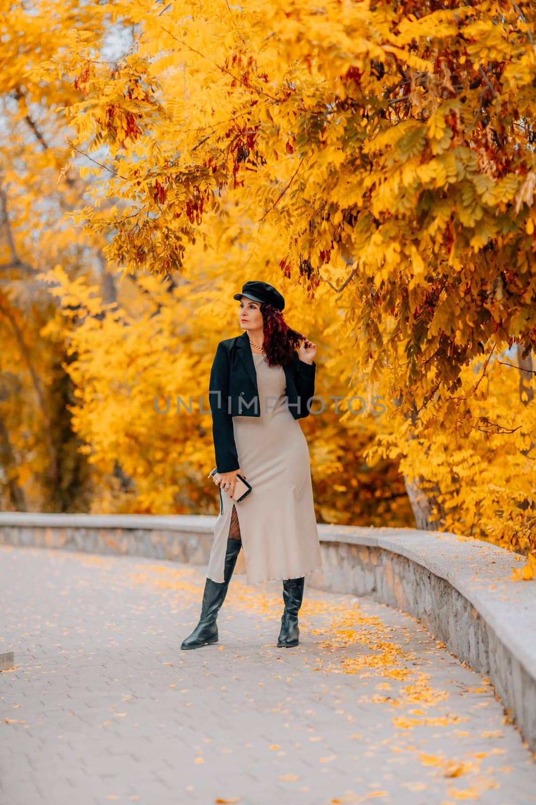 A woman walks outdoors in autumn, enjoys the autumn weather. by Matiunina