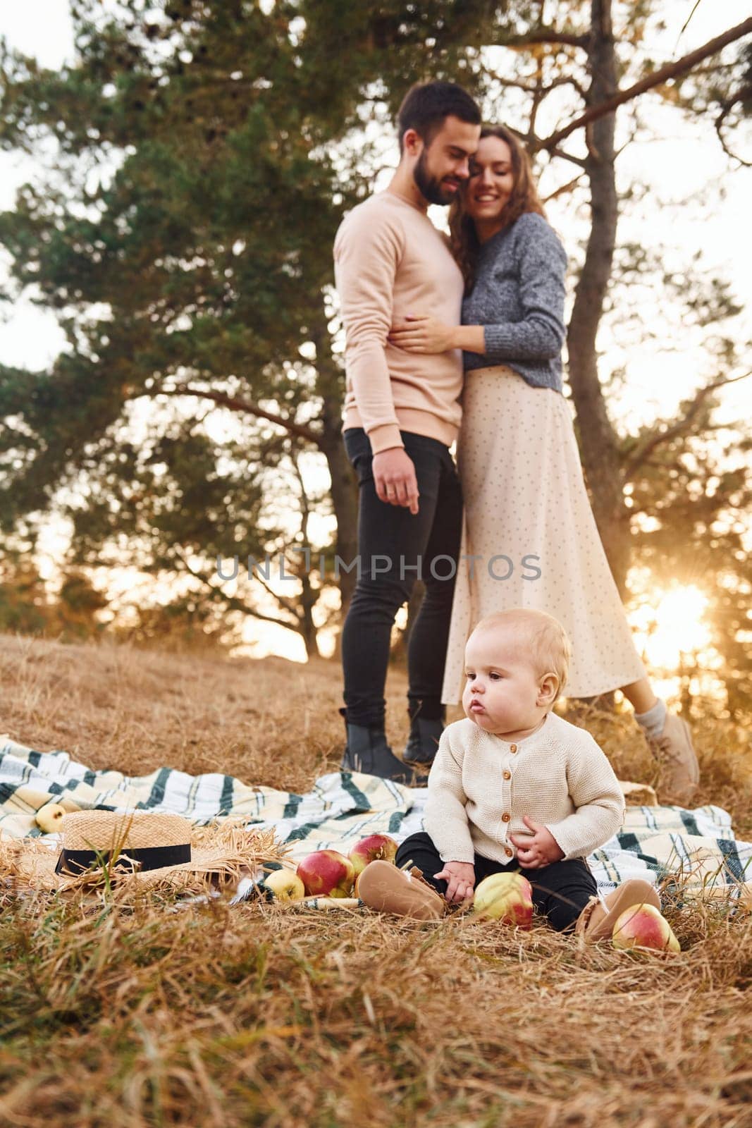 Haves picnic. Happy family of mother, family and little baby rests outdoors. Beautiful sunny autumn nature.