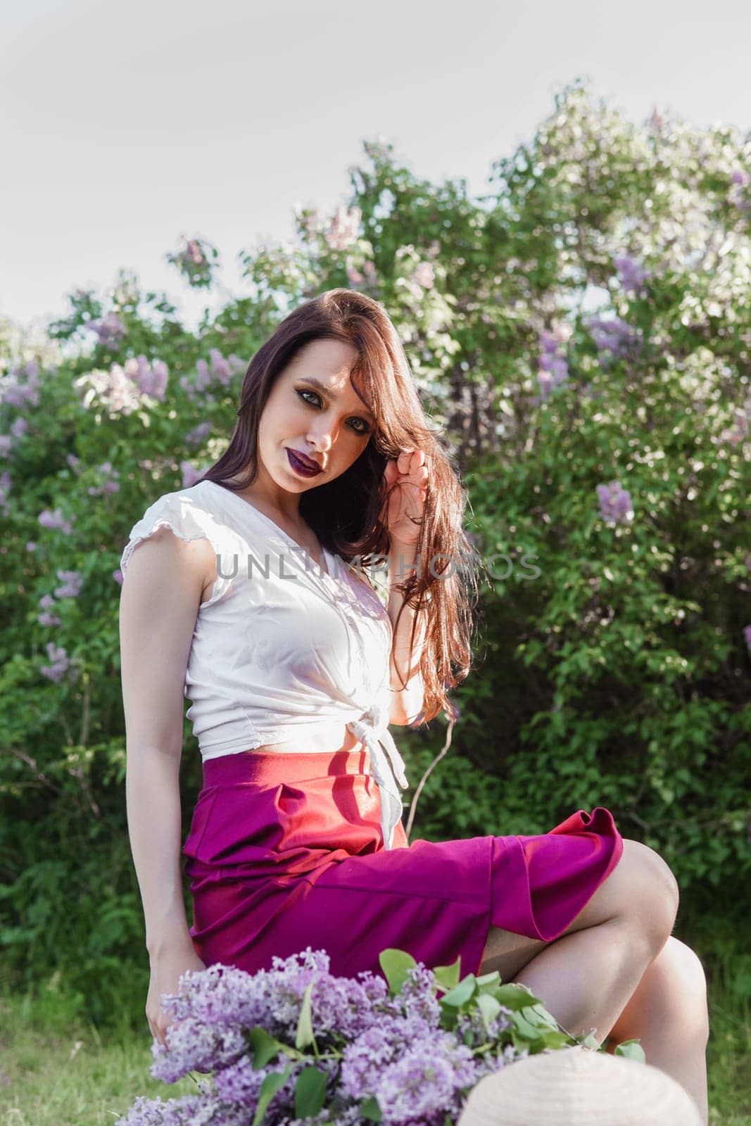 A fashionable girl with dark hair, a spring portrait in lilac tones in summer. Bright professional makeup