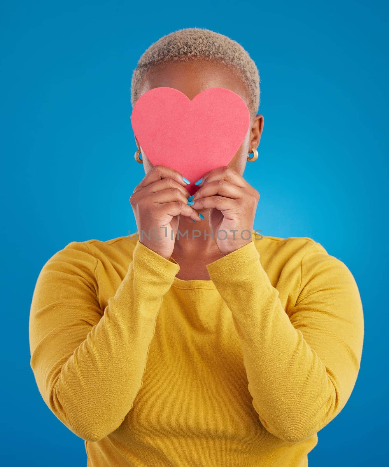 Paper, heart and hide with black woman in studio for love, date and kindness. Invitation, romance and feelings with female and shape isolated on blue background for emotion, support and affectionate.
