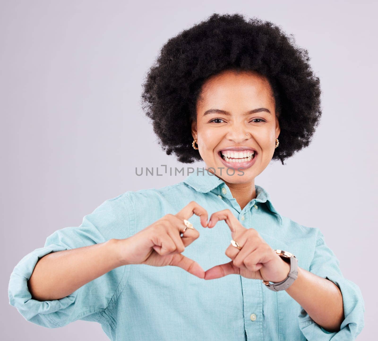 Black woman, studio portrait and heart hands with afro, smile and romance icon with love, confidence and face. Happy african, model and emoji for happiness, date and romantic sign by gray background.