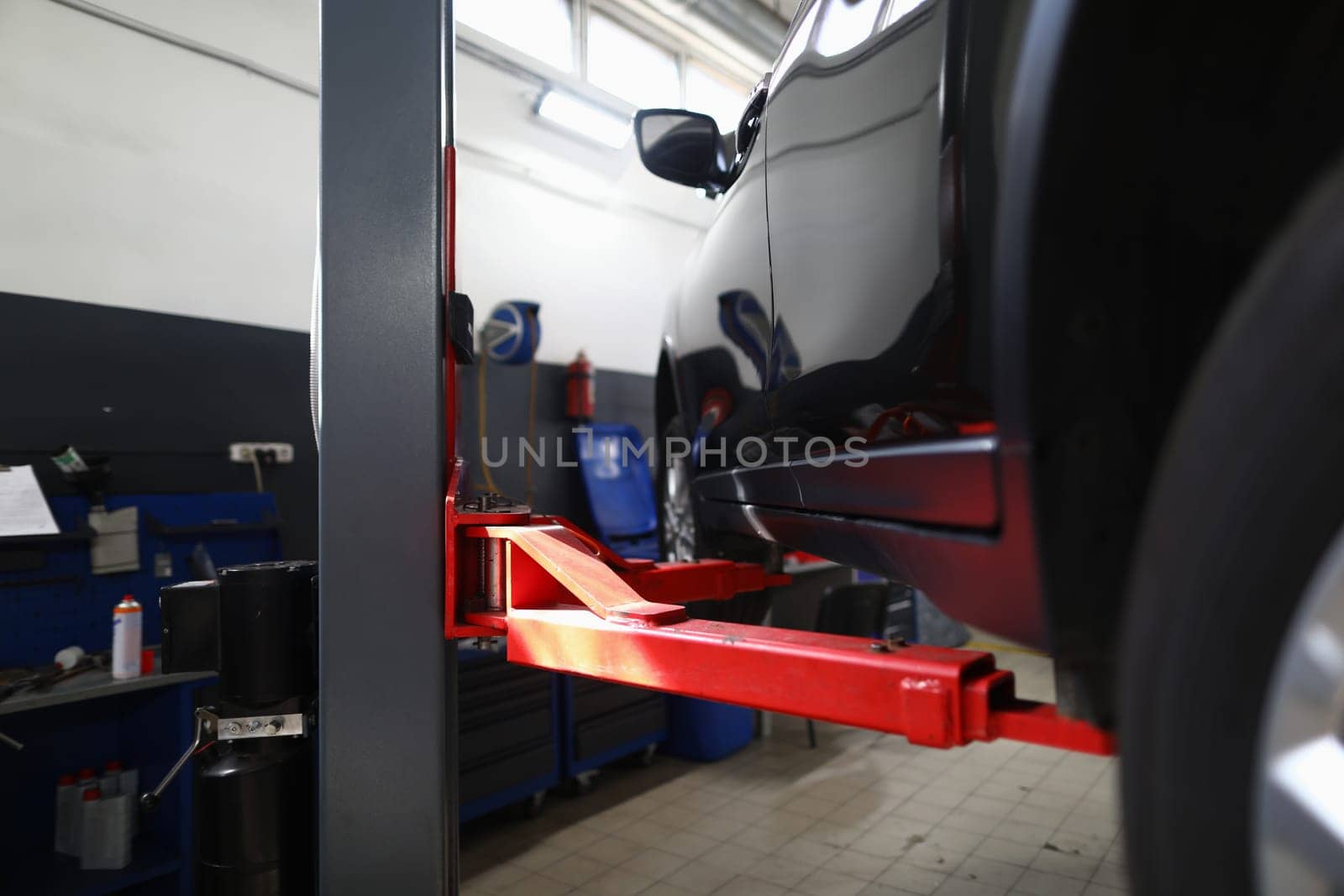 Modern car SUV on lift in service center. Concept of maintenance and repair of warranty car insurance