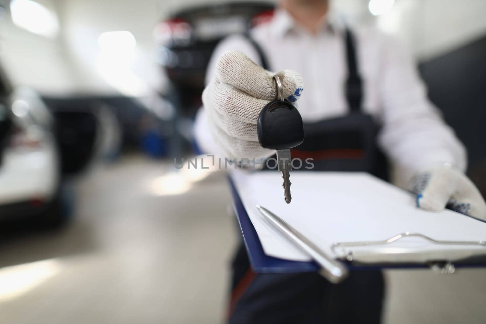 Auto mechanic holds clipboard and car keys by kuprevich