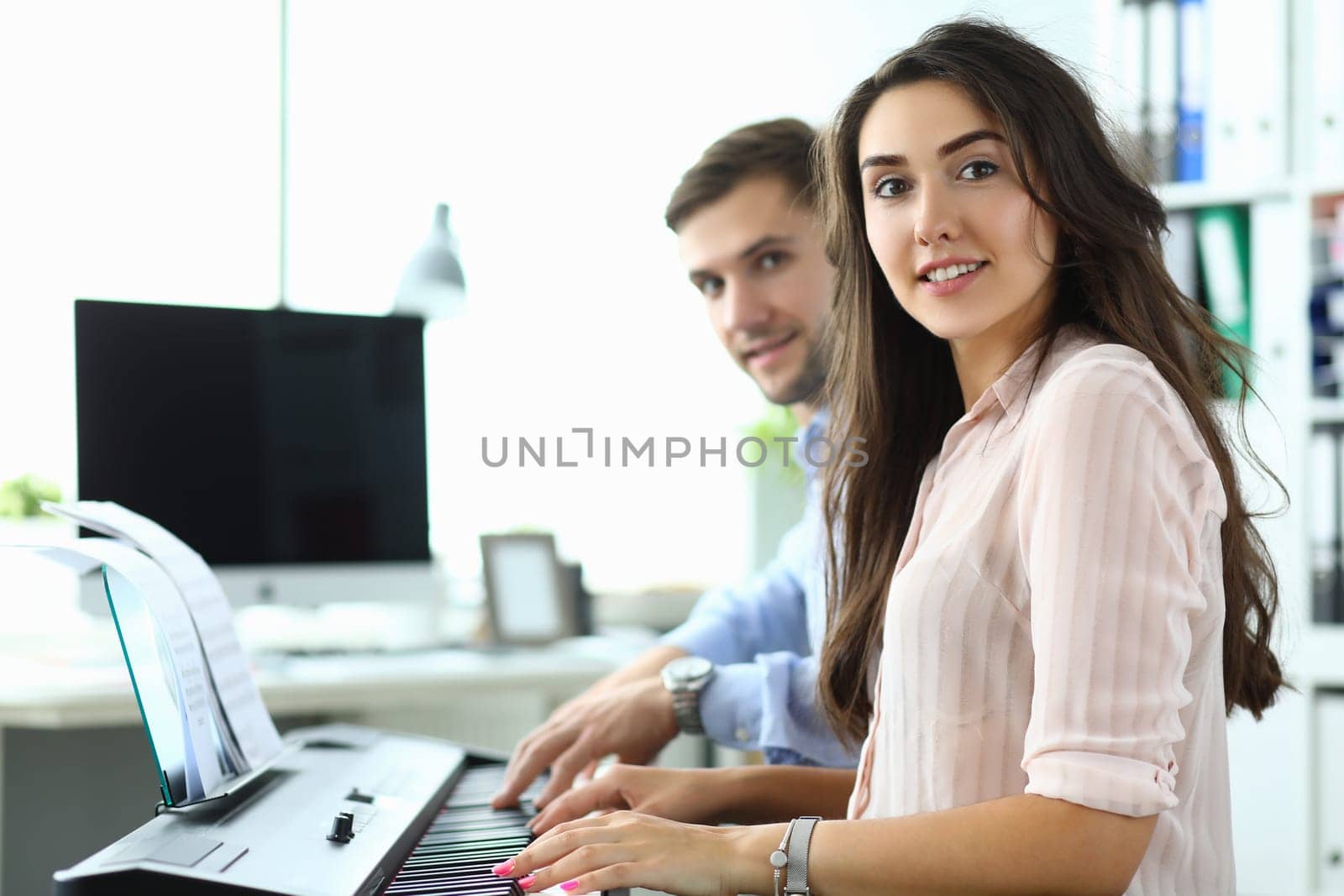 Man and a woman are learning to play synthesizer at home by kuprevich