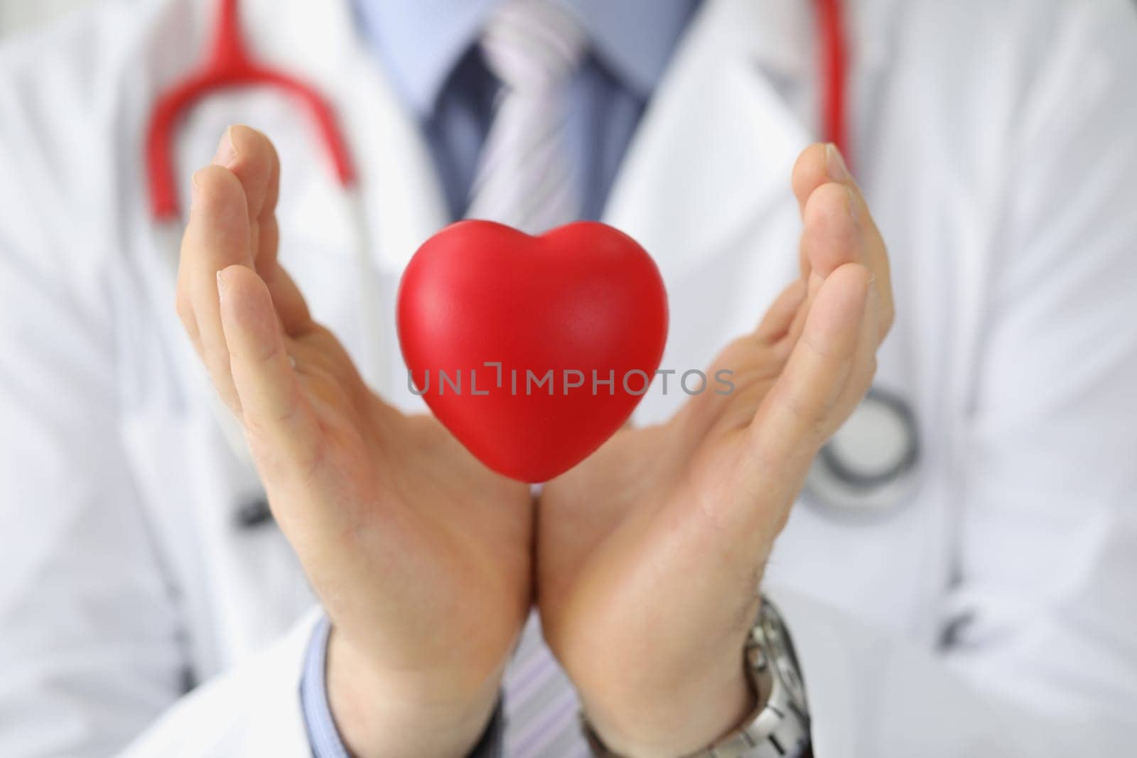 Doctor cardiologist holds red heart in air. Heart transplantation and cardiovascular disease