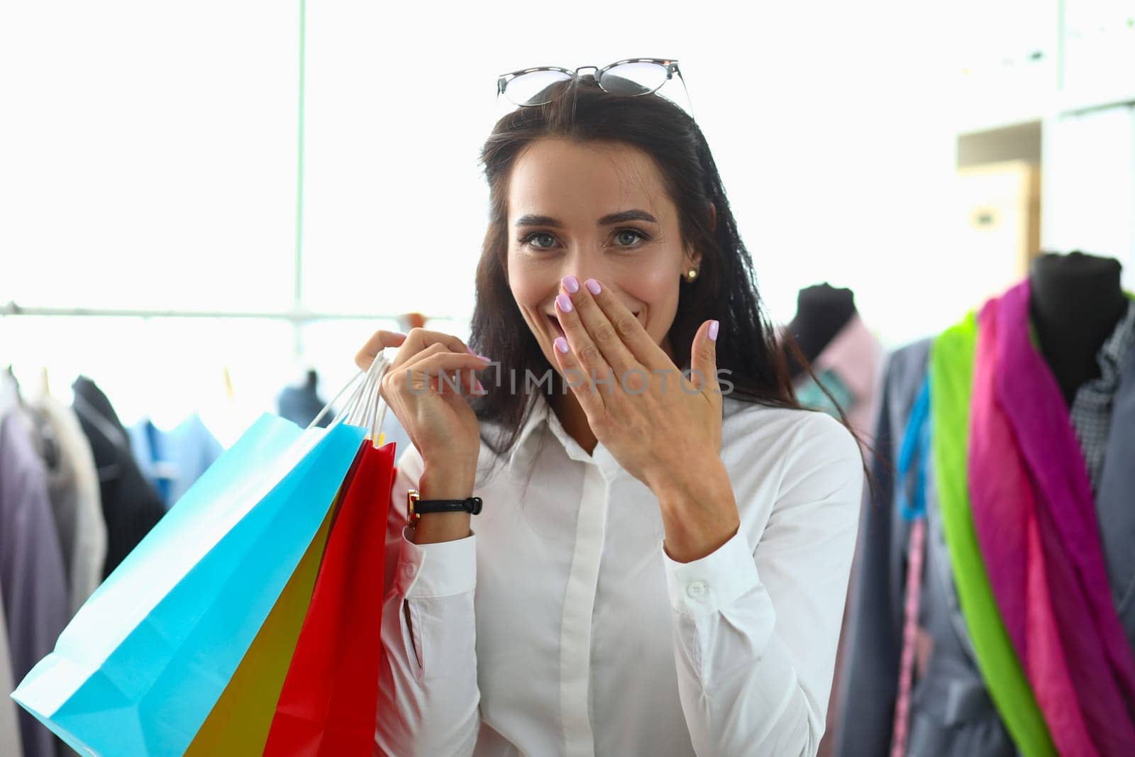 Laughing happy joyful woman with shopping bags in fashionable clothing store. Promotions with discounts and shopping for pleasure