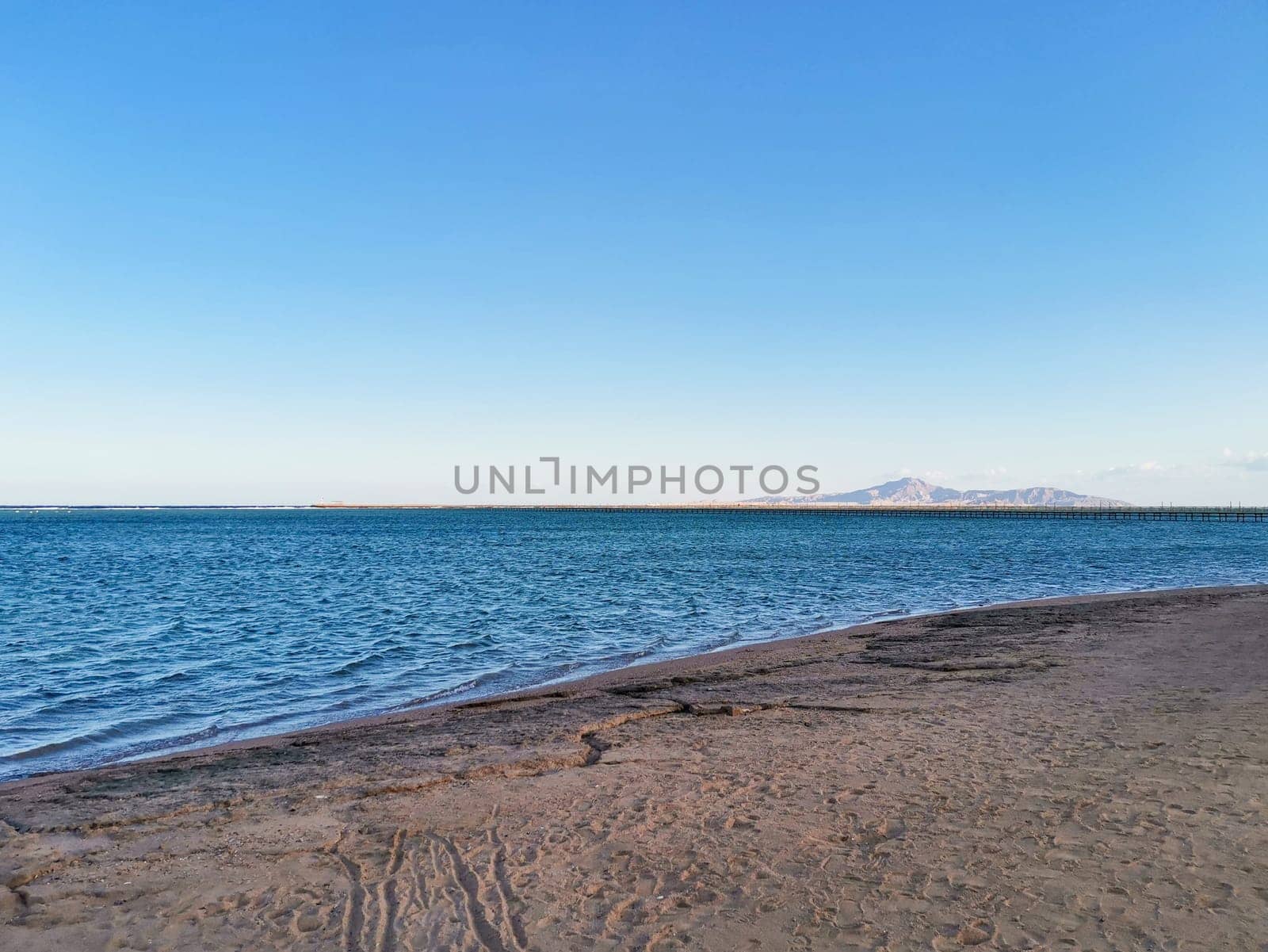 Sea coast on quiet day. Islands on the horizon. Quiet ocean water