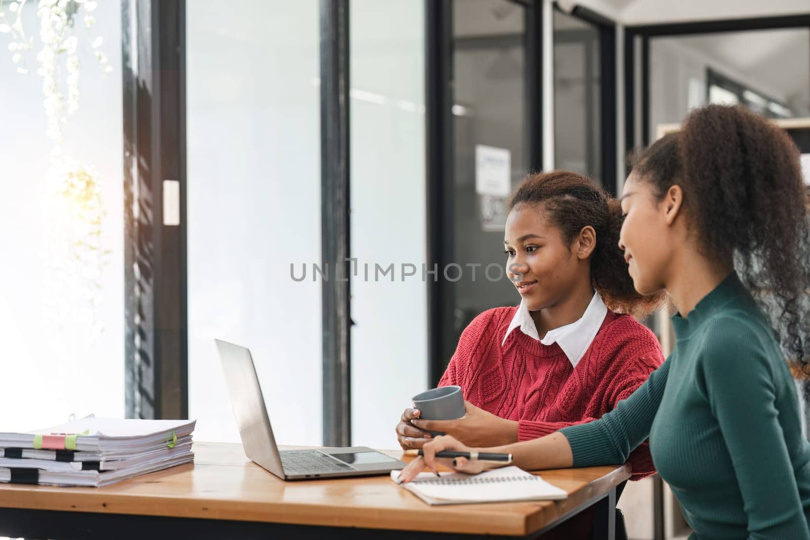 Young group of diverse students studying together using laptop at home. College multiracial people working on university group assignment homework project in modern apartment by nateemee