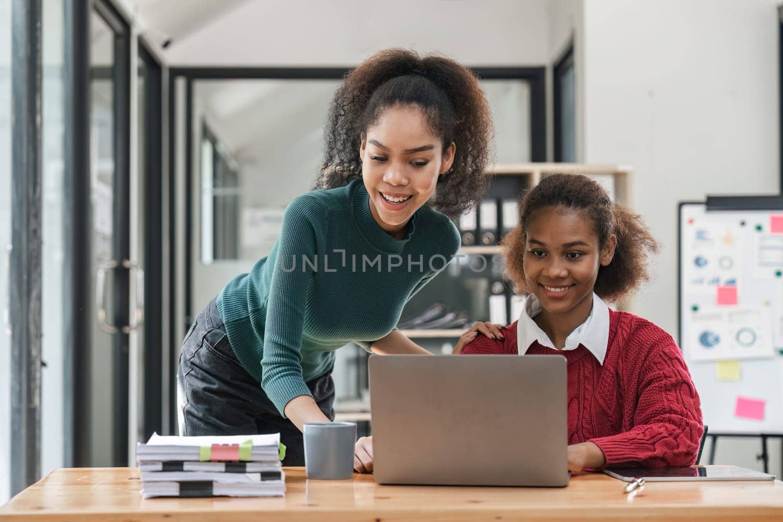 Young group of diverse students studying together using laptop at home. College multiracial people working on university group assignment homework project in modern apartment by nateemee