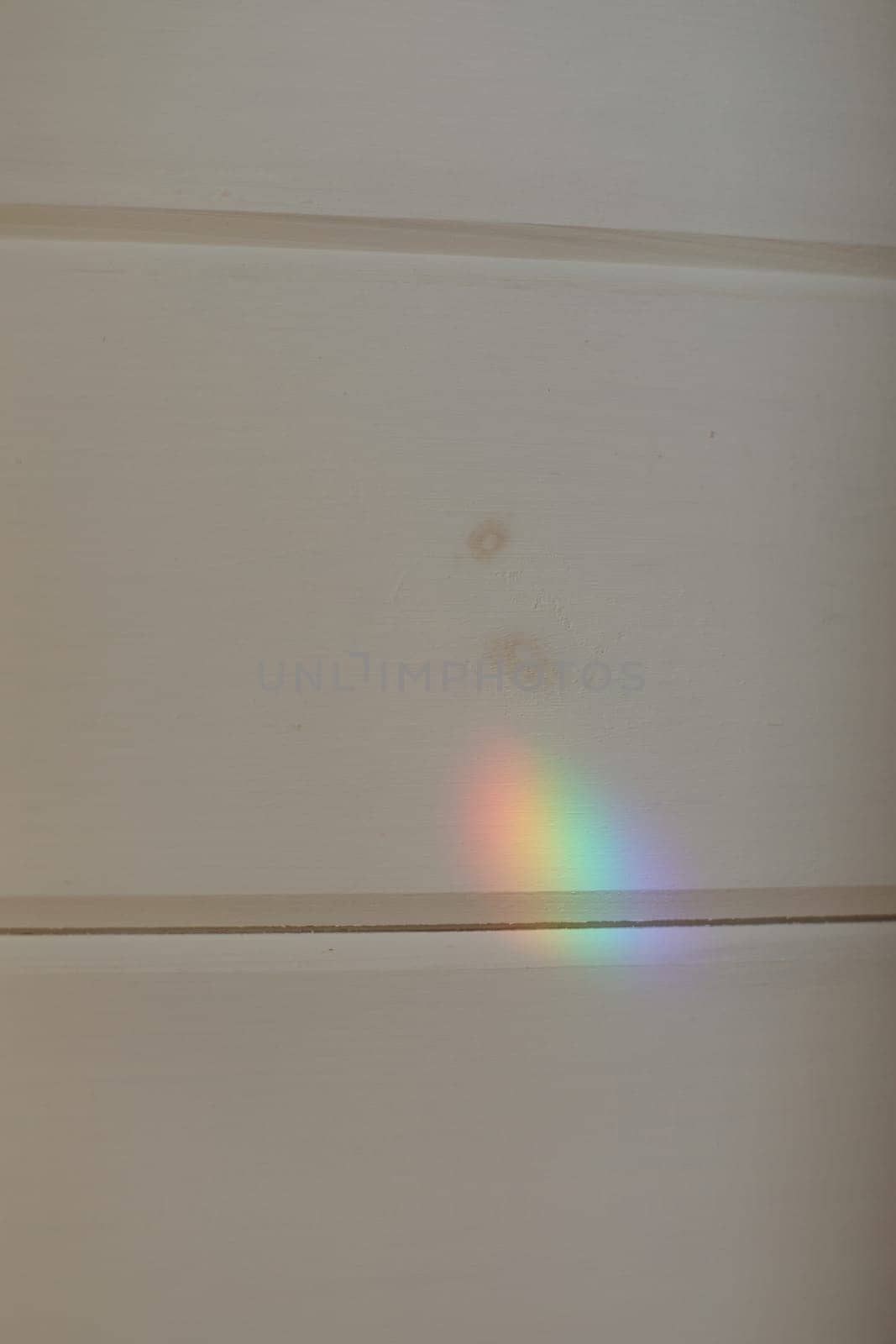 Abstract natural light rainbow on white wall mock up. light refraction on white wall, blurred sun rays refracting through glass prism with shadow.