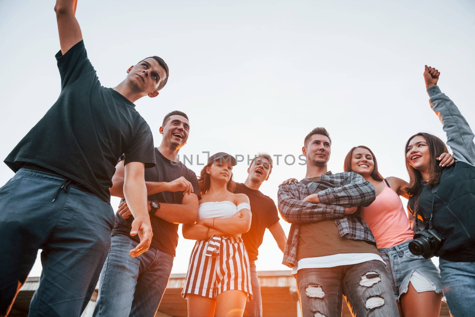 Posing for a camera. Group of young cheerful friends having fun together. Party outdoors.