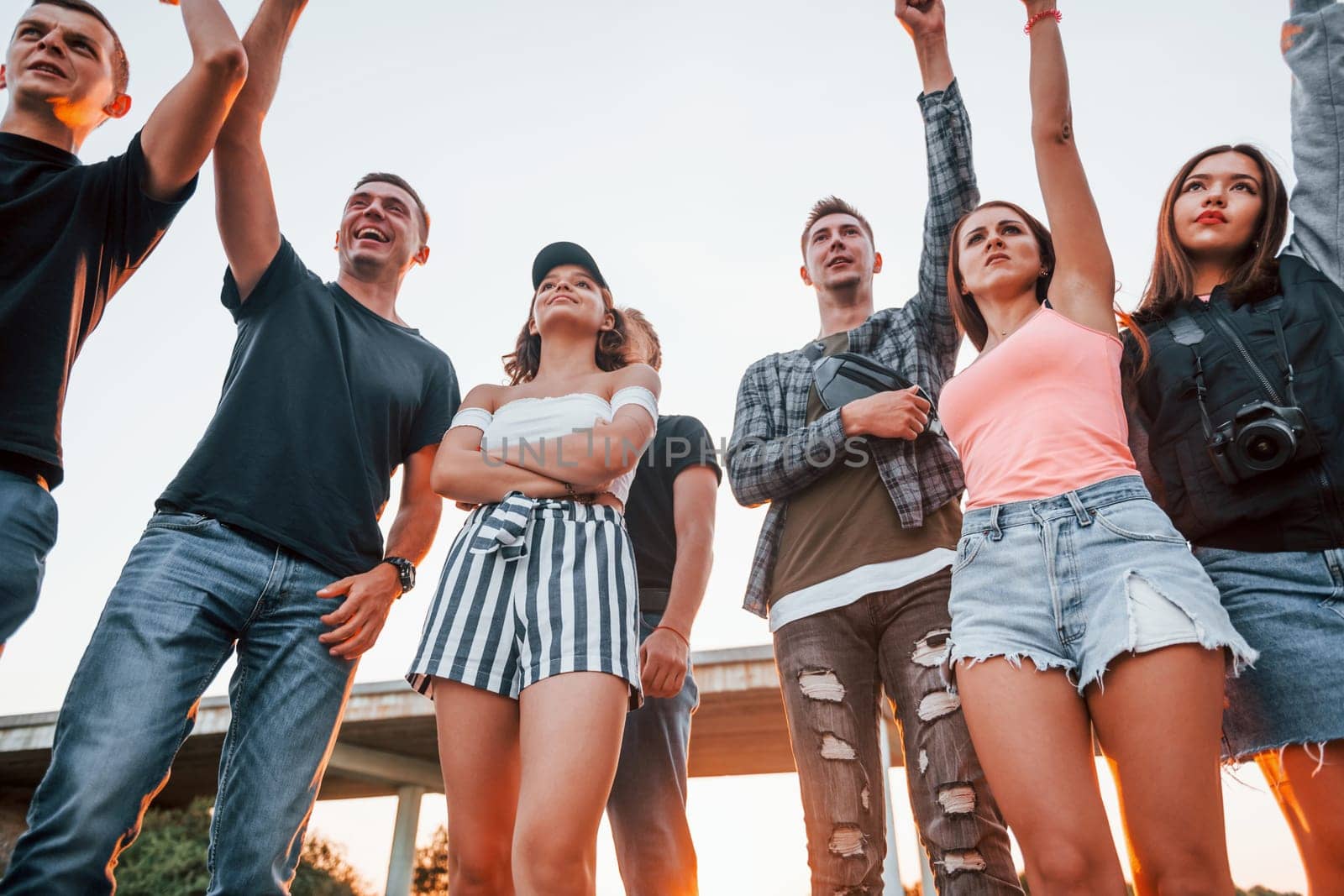 Posing for a camera. Group of young cheerful friends having fun together. Party outdoors.