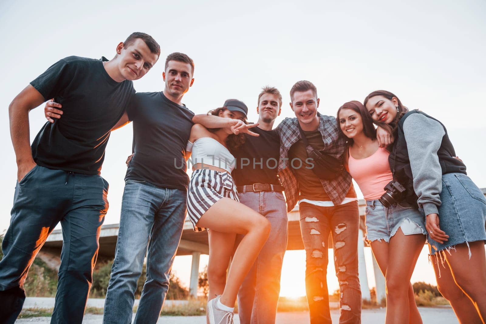 Embracing each other. Group of young cheerful friends having fun together. Party outdoors.