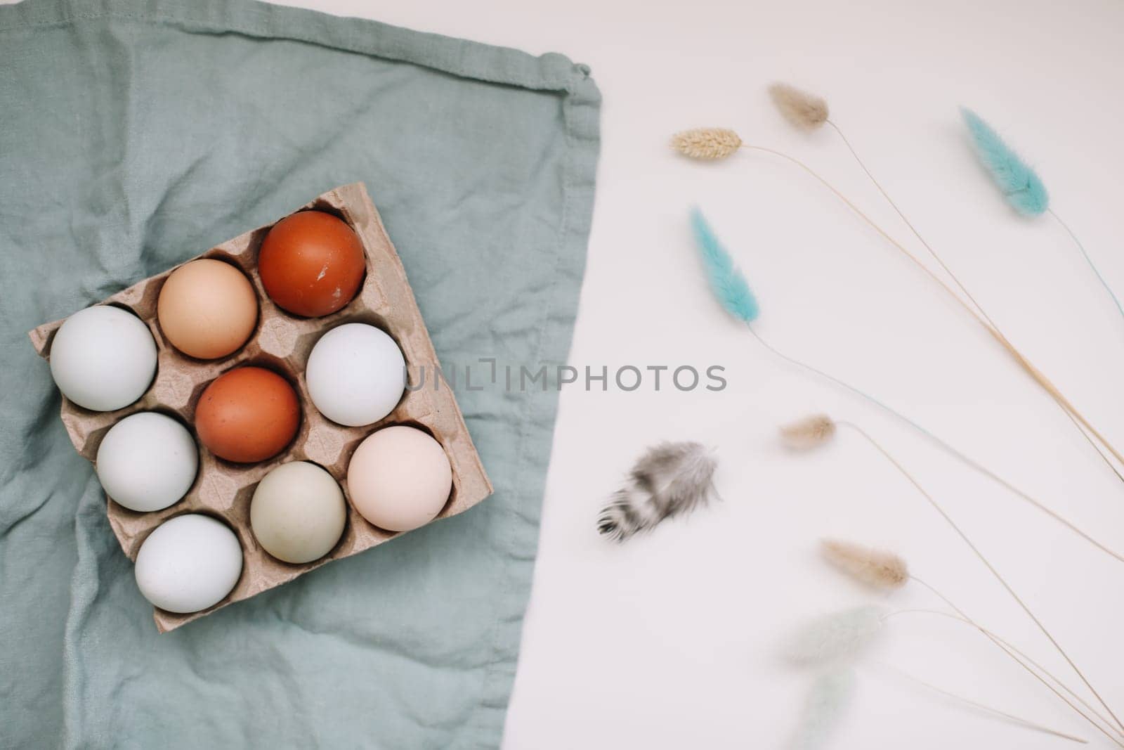 fresh chicken eggs of natural shades and colors in a recycled box on a white background.