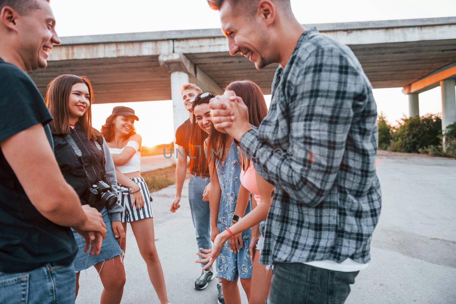 Talking and laughing. Group of young cheerful friends having fun together. Party outdoors.