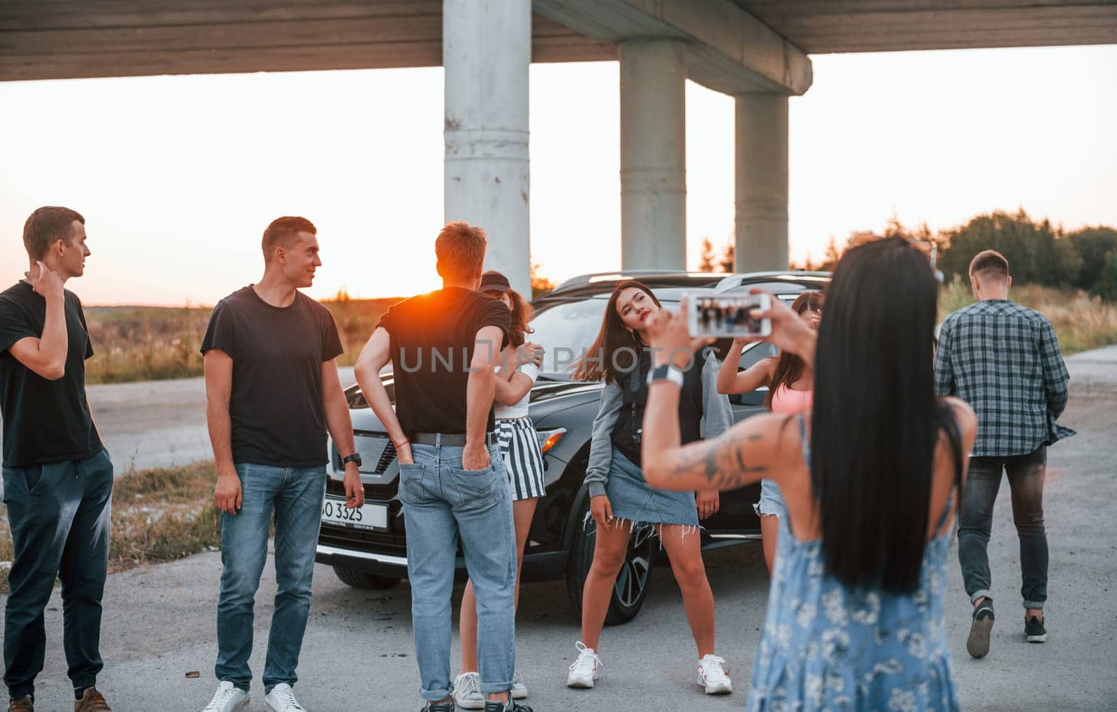 Talking and laughing. Group of young cheerful friends having fun together. Party outdoors.