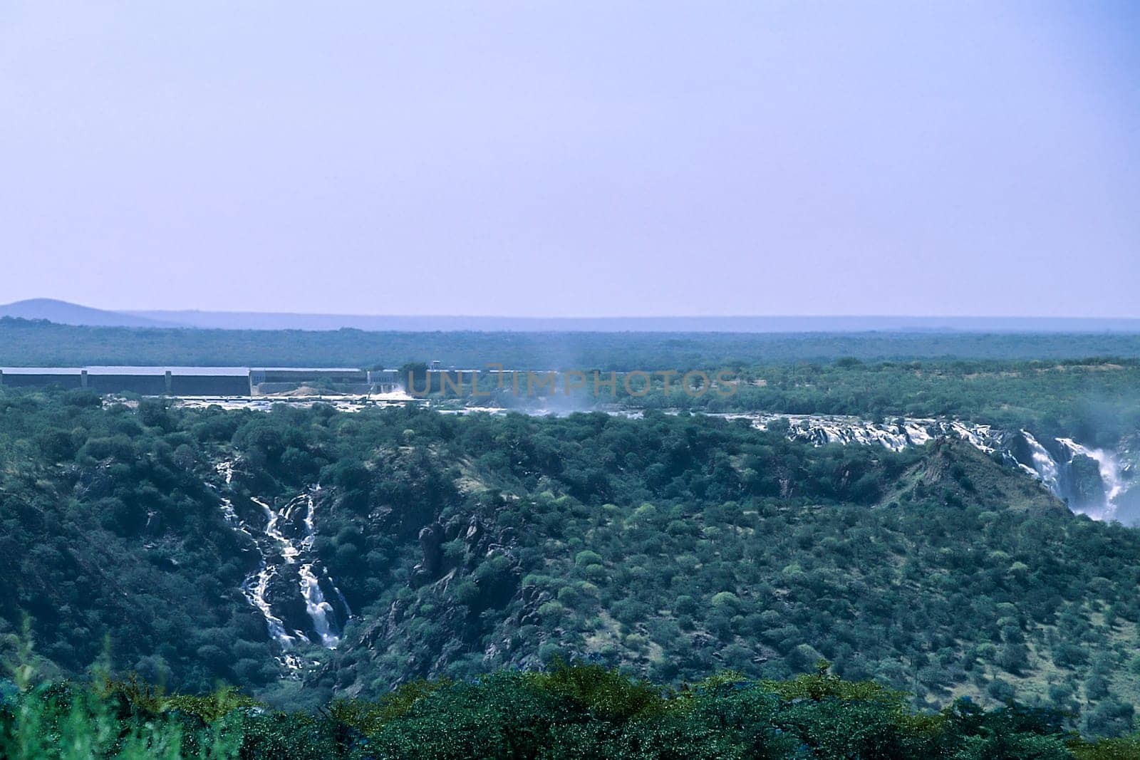 Panoramic view of Ruacana Falls. Located near Ruacana on the Kunene River in Northern Namibia. The waterfall is 120 meters (390 ft) high and 700 meters (2,300 ft) wide in full flood. It is among the largest waterfalls in Africa, both by volume and width. Africa, Namibia, Kaokoland