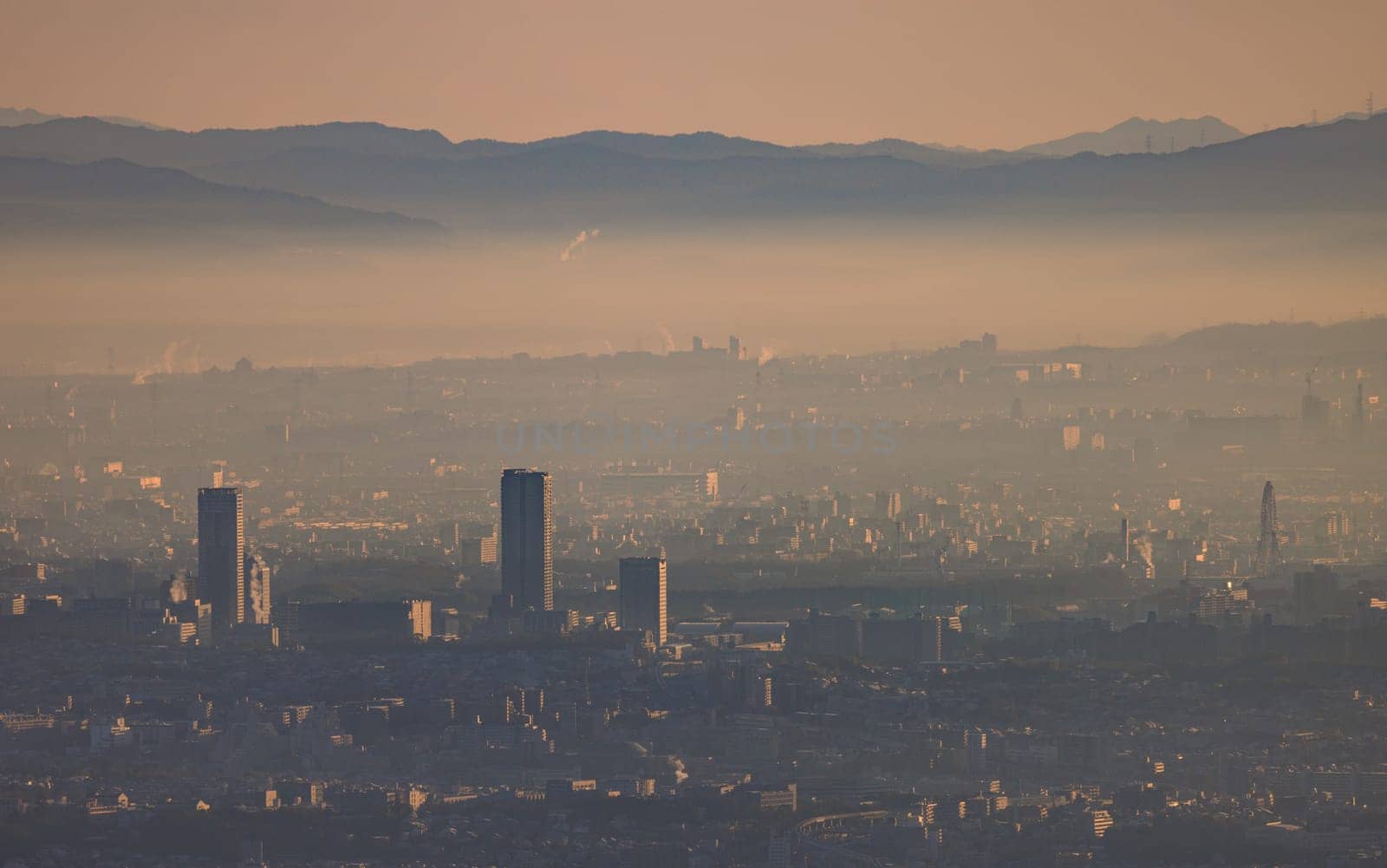 Early morning smog and haze over high rise apartments in sprawling city by Osaze