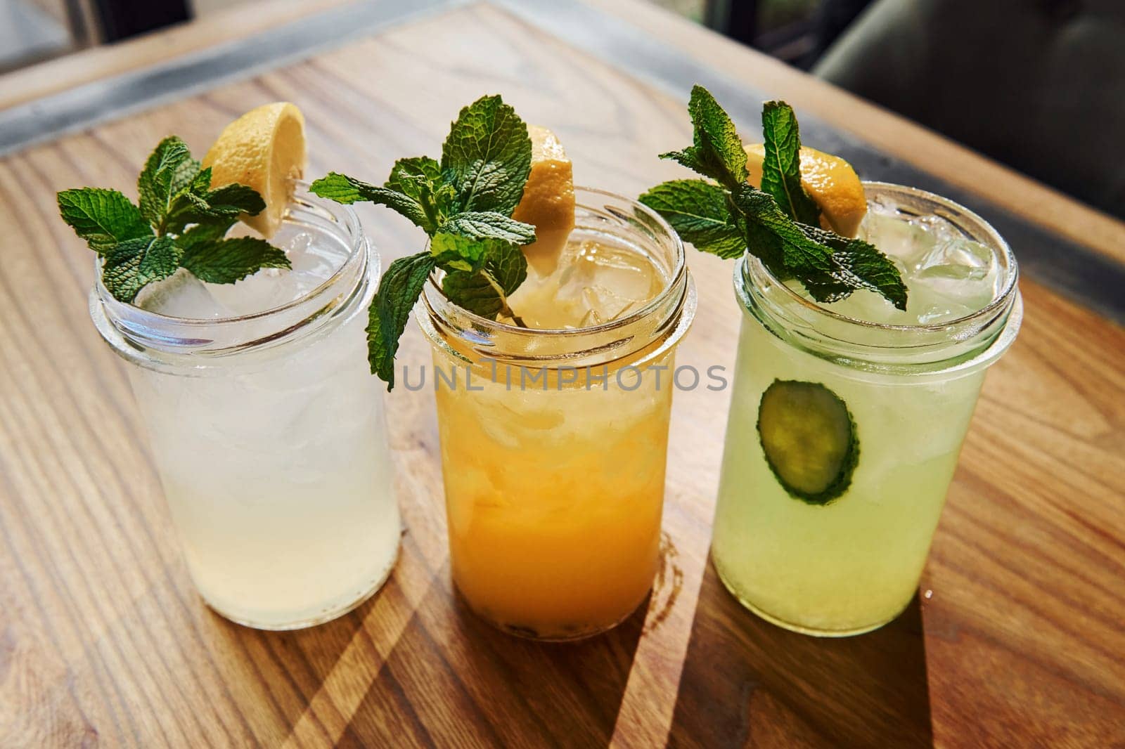 Yellow and green colored. Close up view of fresh summer alcoholic cocktails on the wooden table.