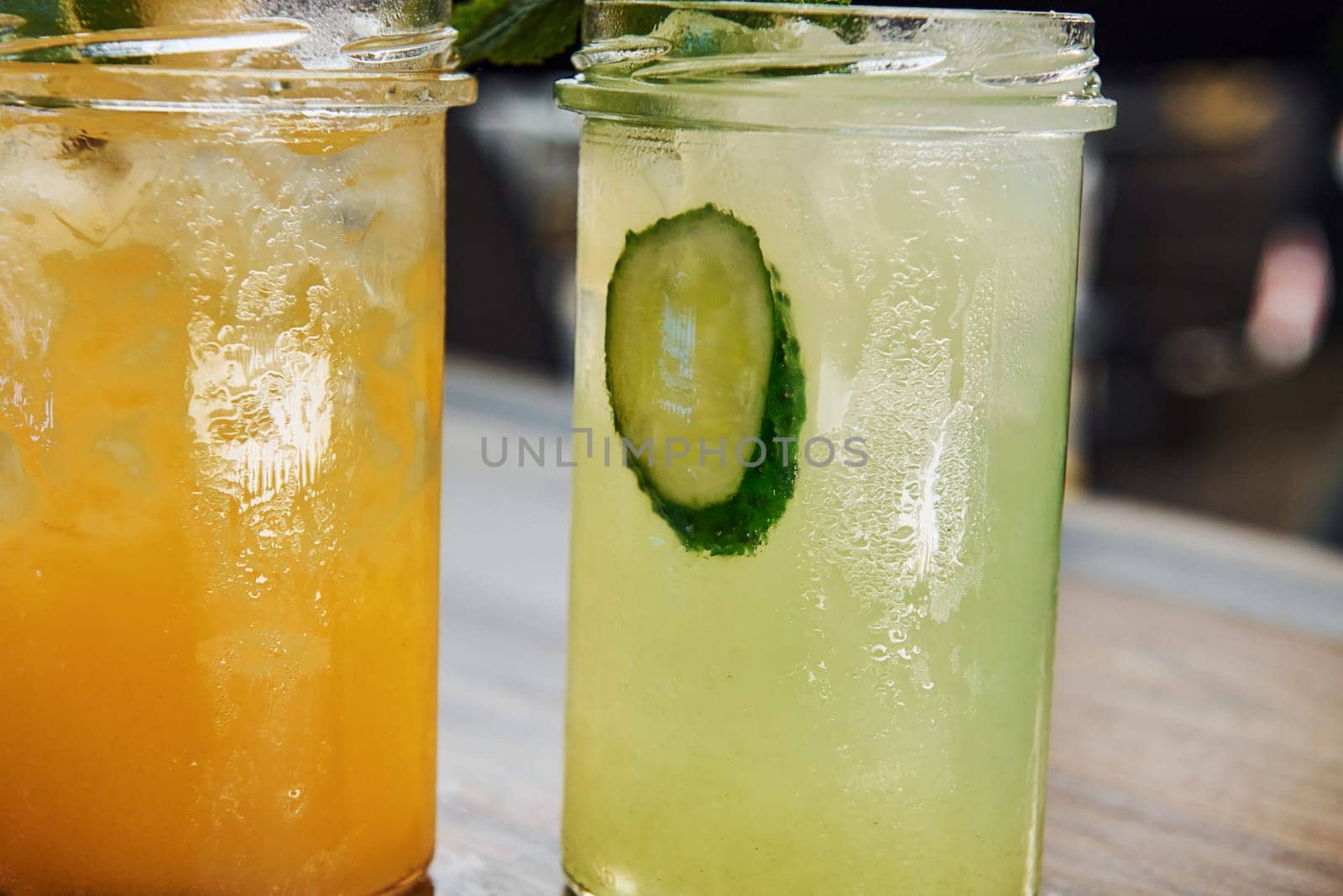 Yellow and green colored. Close up view of fresh summer alcoholic cocktails on the wooden table.