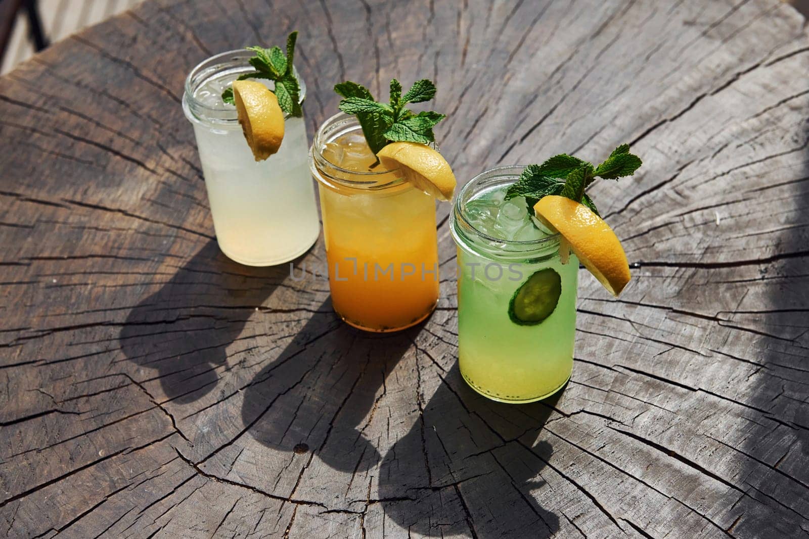 Yellow and green colored. Close up view of fresh summer alcoholic cocktails on the wooden table.