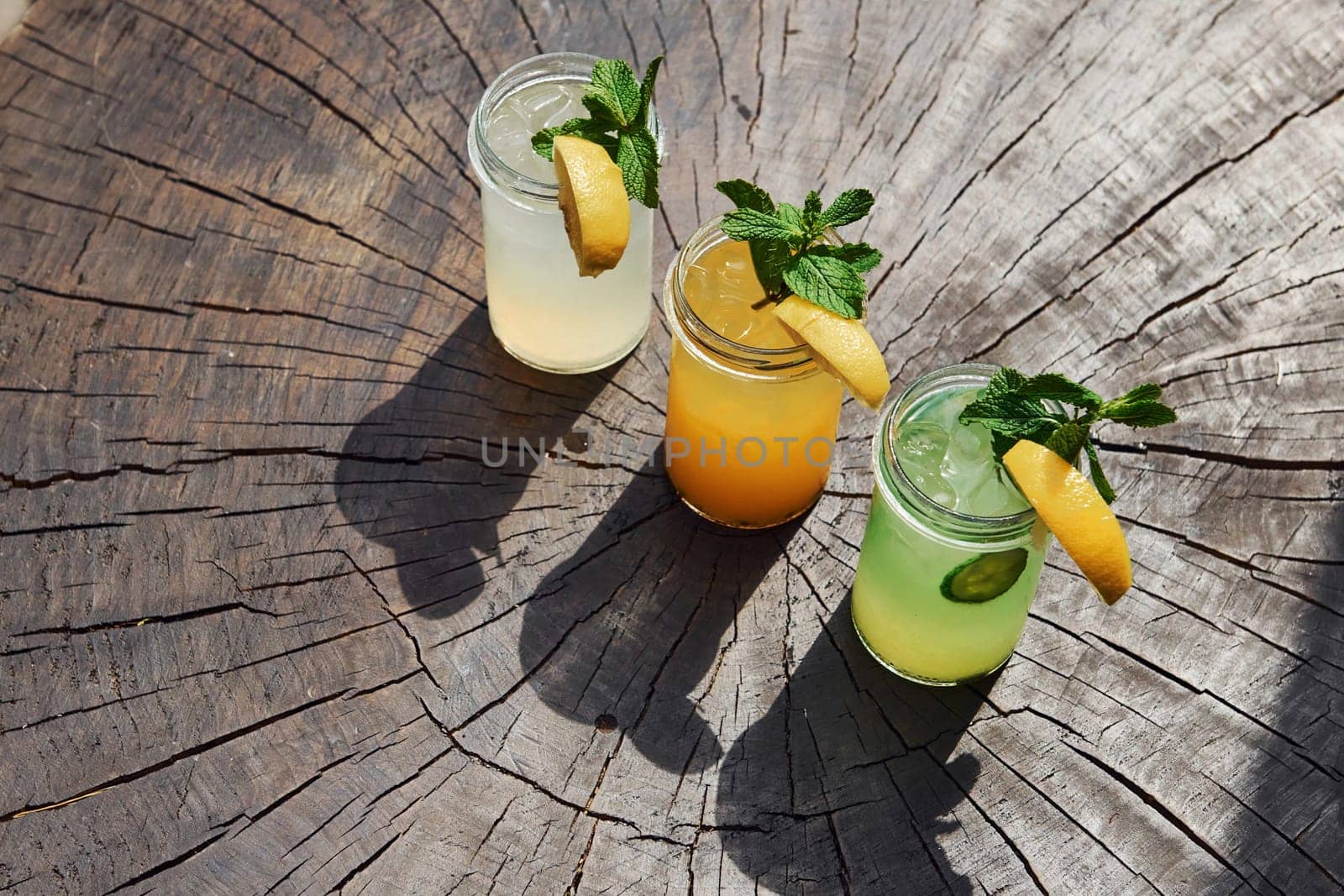 Yellow and green colored. Close up view of fresh summer alcoholic cocktails on the wooden table.