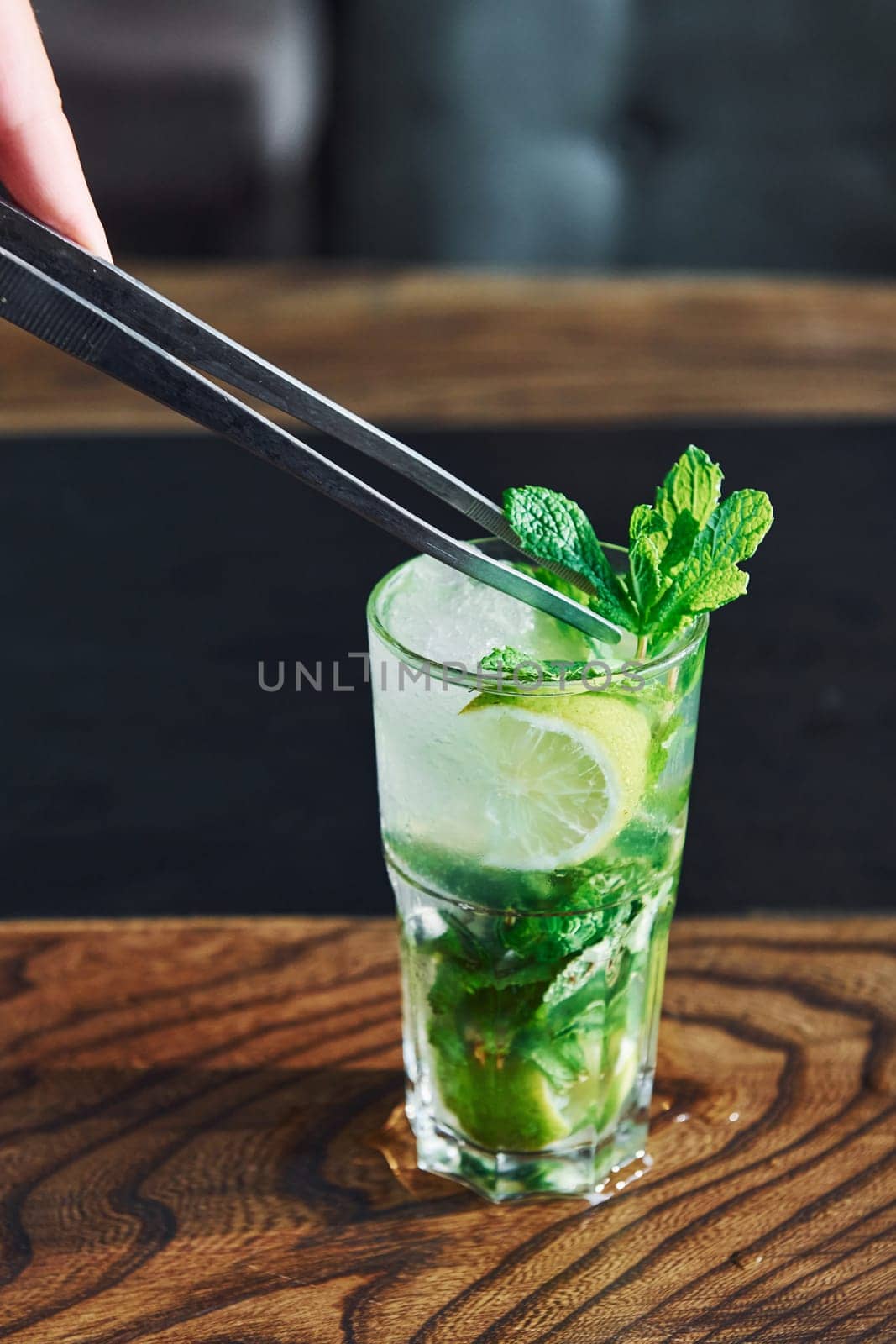 Close up view of fresh summer non alcoholic mojito cocktail on the wooden table.