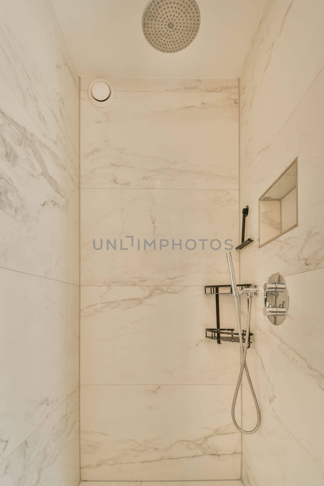 a bathroom with marble walls and white tiles on the shower wall, there is an overhead shower head in the corner