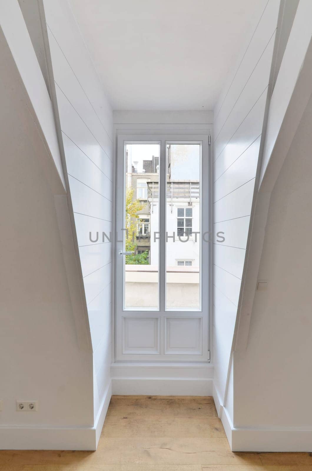 a narrow hallway with white walls and a window by casamedia