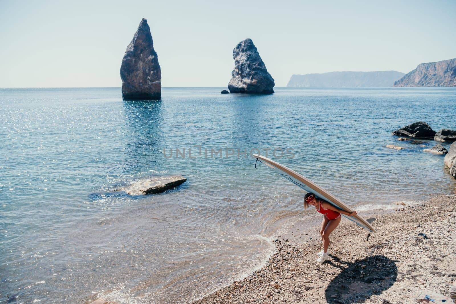 Woman sea sup. Close up portrait of happy young caucasian woman with blond hair looking at camera and smiling. Cute woman portrait in red bikini posing on sup board in the sea by panophotograph