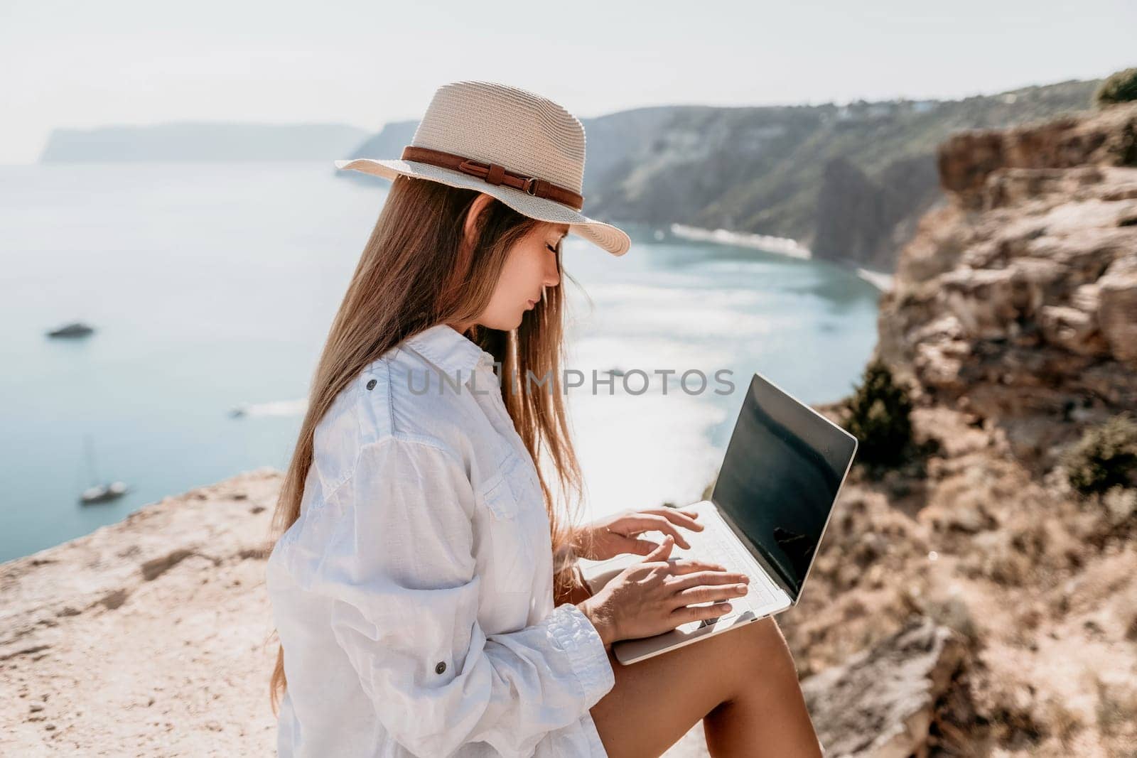 Happy girl doing yoga with laptop working at the beach. beautiful and calm business woman sitting with a laptop in a summer cafe in the lotus position meditating and relaxing. freelance girl remote work beach paradise